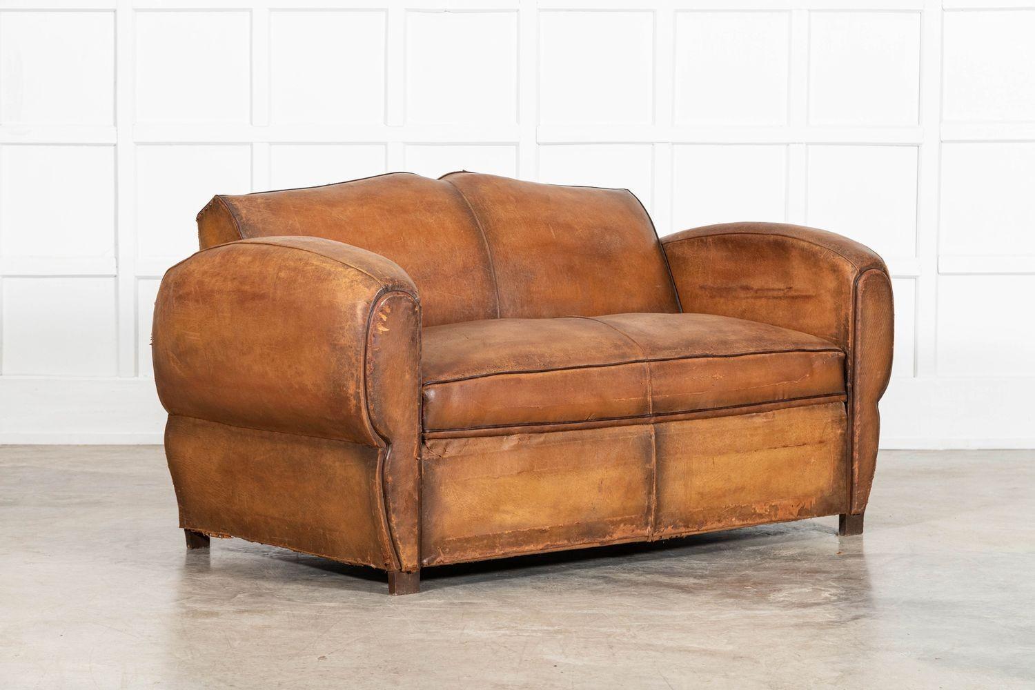 circa 1930
French Leather Moustache Back Club Sofa Bed
sku 0000B
The sofa converts to a sofa bed with a pull out mechanism with springs - just a mattress topper is required. The reverse of the sofa has been recovered and studded as the original