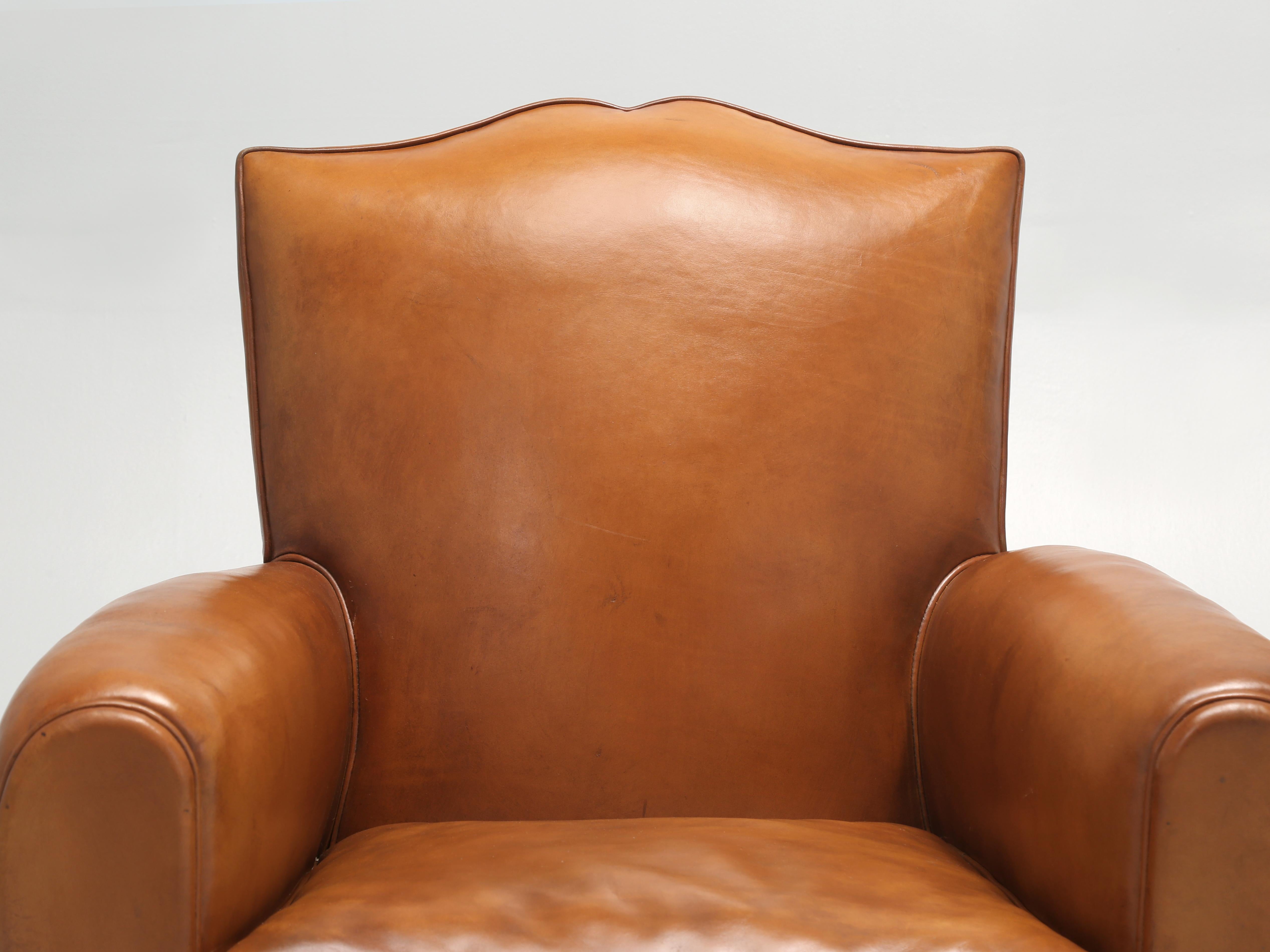 Pair of French Leather Club Chairs that have been painstakingly restored from the bare wood frame on up. Generally, our inhouse Old Plank Upholstery Department is successful in resurrecting old dead leather, however in this particular instance we