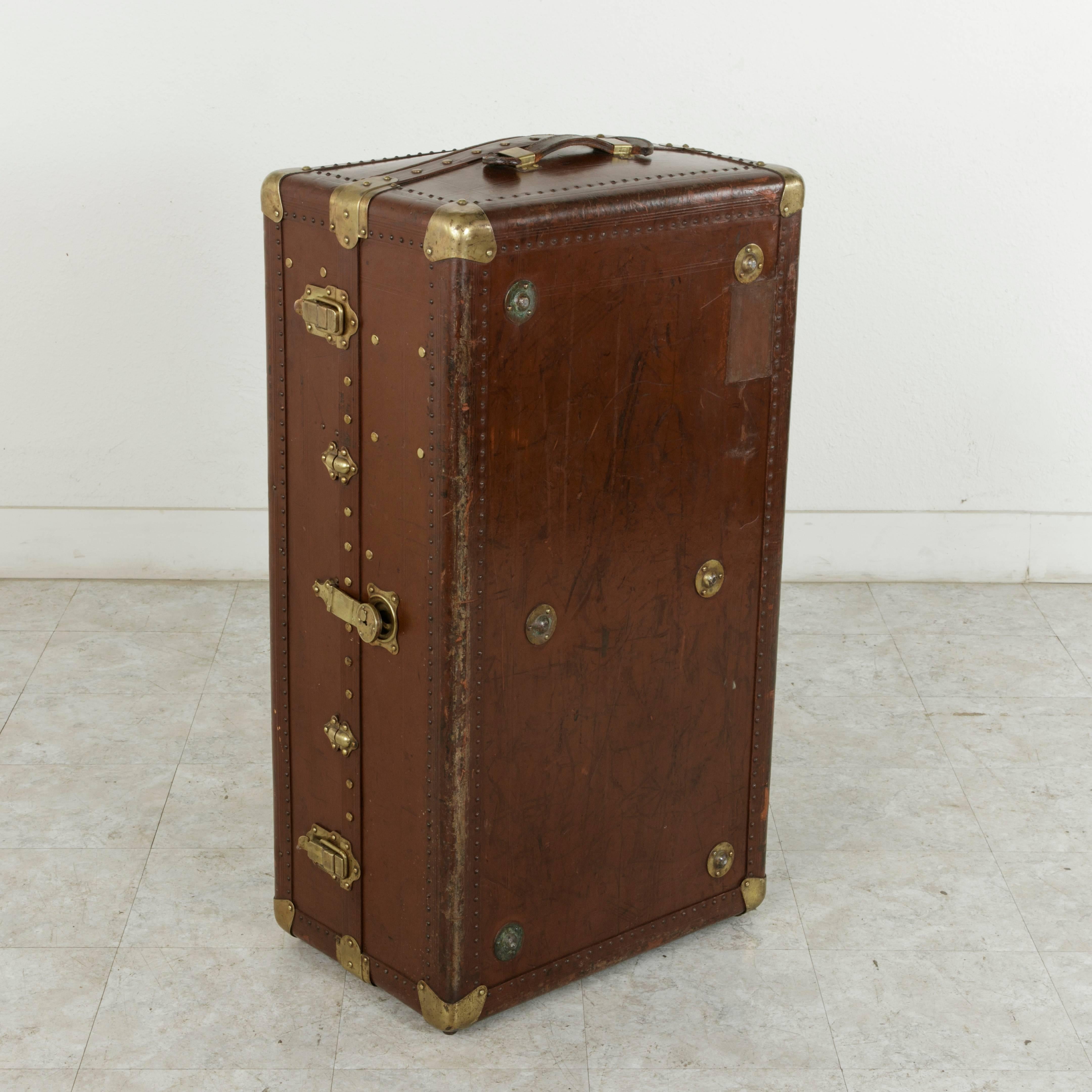 A piece of world traveling history, this leather steam trunk has its own story to tell. It bears its original aged travel sticker from Nancy-Ville, a city in the region of Lorraine, France. This early 20th century steam trunk features numerous
