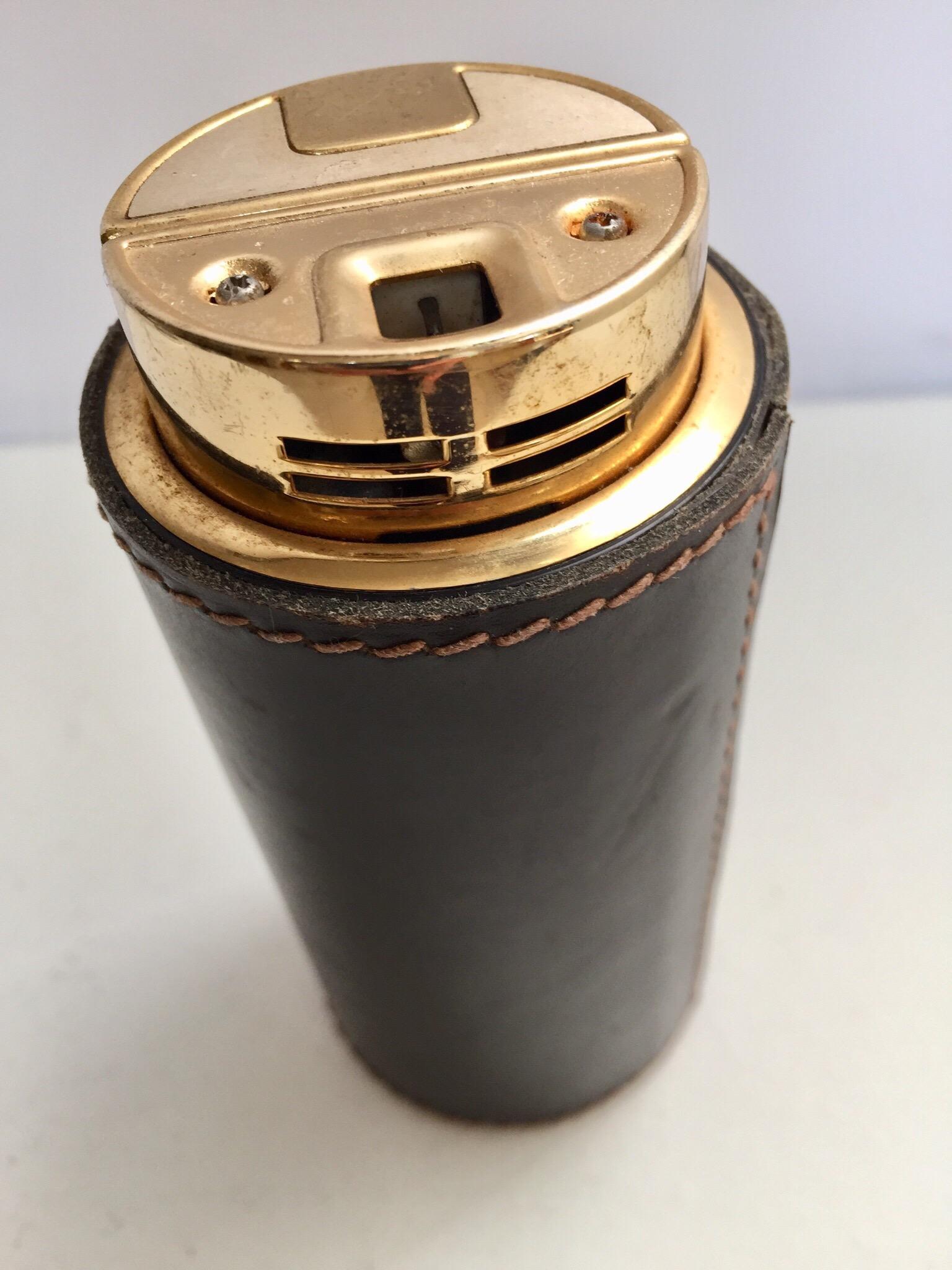 French leather Art Deco table lighter by Delvaux Paris.
Handstitched rich deep brown leather table lighter in brass. 
Handmade in the middle of the 1950s.
Excellent vintage condition. Great decorative brass and leather Art Deco collectible rare