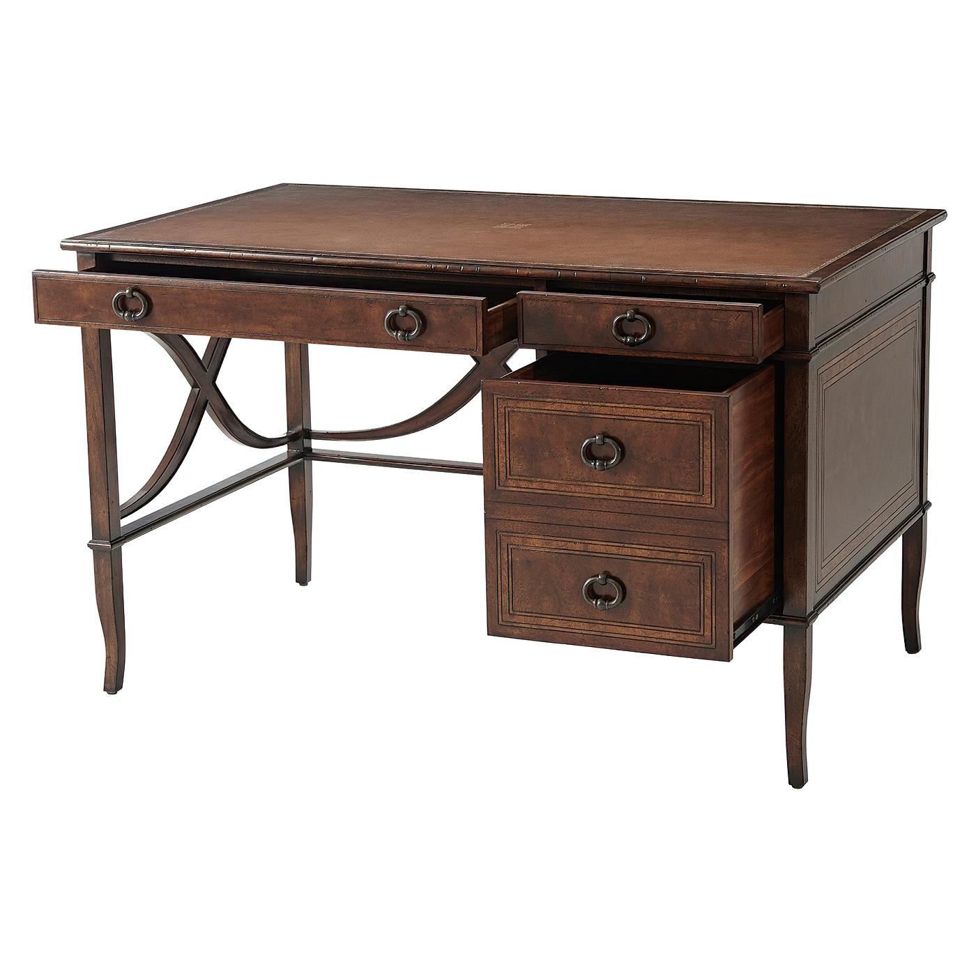 A French neoclassic style mahogany, cerejeira veneered and crossbanded writing desk, the rectangular burnished leather inlaid top above one long and one short frieze drawers, and an additional deep drawer below, the sides with wavy 'X' stretchers