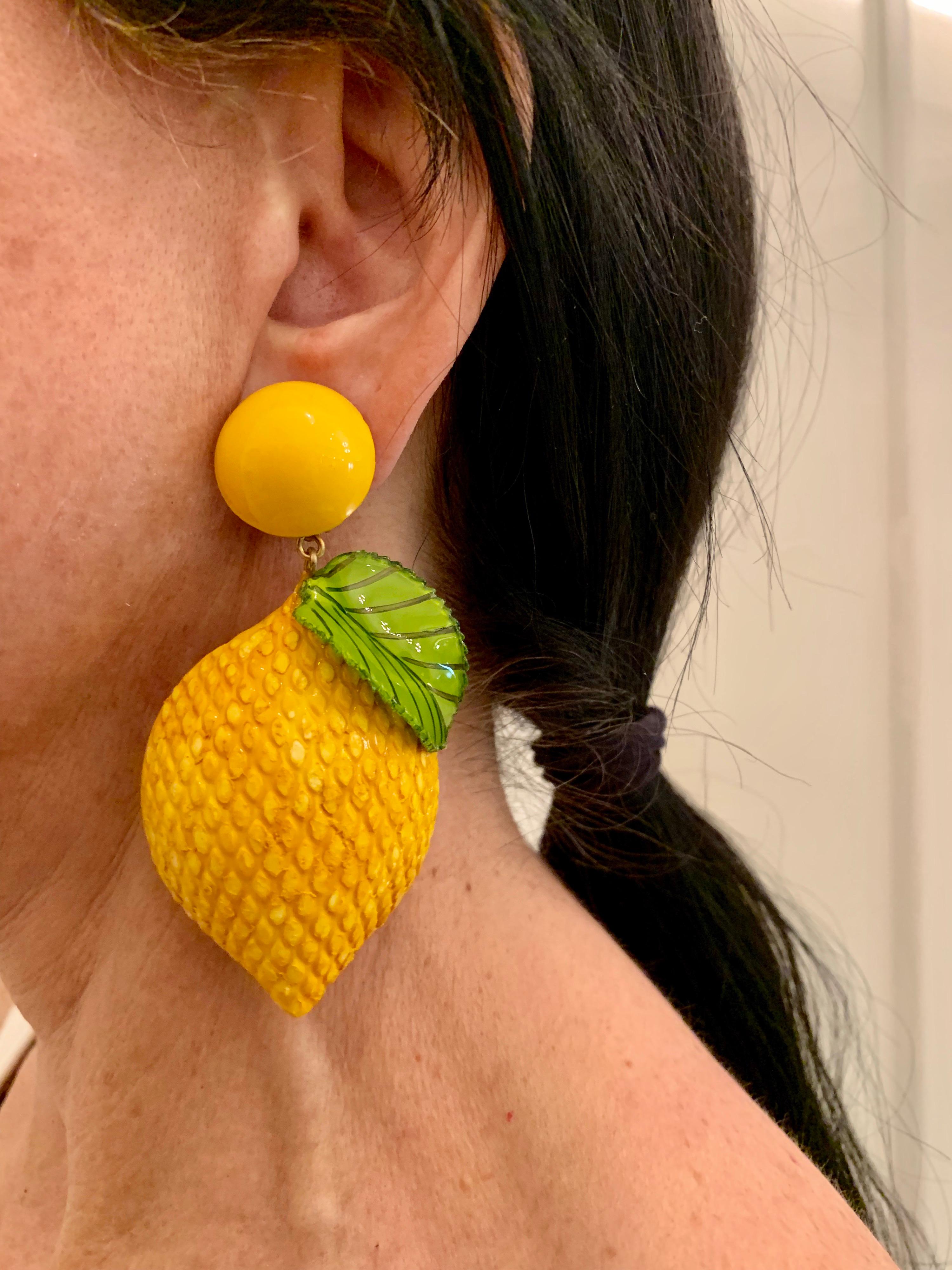 Light and easy to wear, these contemporary handmade artisanal clip-on statement earrings were made in Paris by Cilea. The lightweight earrings feature giant lemons, comprised out of enamel and resin. The lemons have a three-dimensional oversized