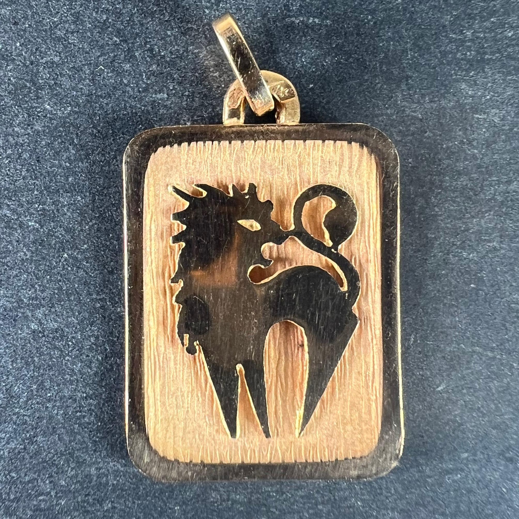 Un ciondolo francese in oro giallo 18 carati (18K) disegnato come una medaglia rettangolare con un incavo inciso raffigurante un leone che rappresenta il segno zodiacale del Leone. Timbro a testa d'aquila per la manifattura francese e oro a 18
