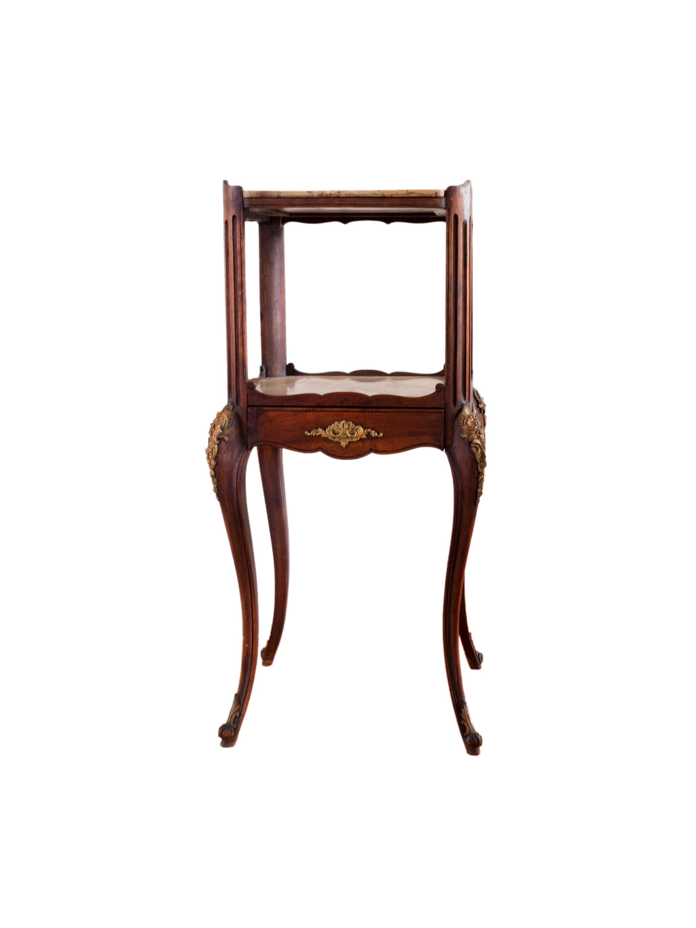 Un élégant porte-liberté en noyer français, magnifiquement sculpté. 
Une pièce Art Nouveau avec un tiroir central unique, un double plateau en marbre dans la partie supérieure et inférieure. 
