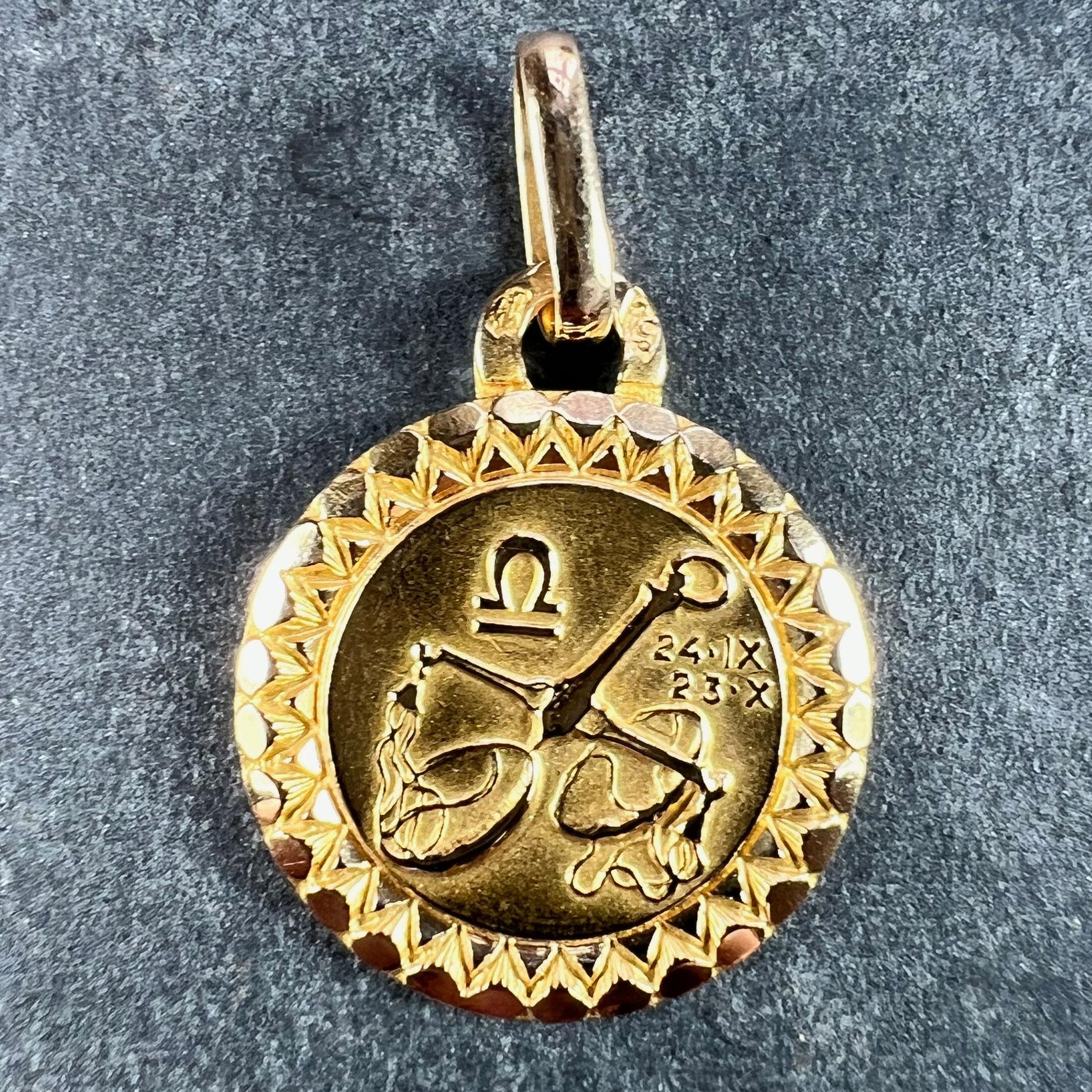 An 18 karat (18K) yellow gold charm pendant designed as the Zodiac sign of Libra, depicting a pair of scales with the dates 24 IX (September) and 23 X (October). Stamped with the eagle mark for 18 karat gold and French manufacture with maker's mark