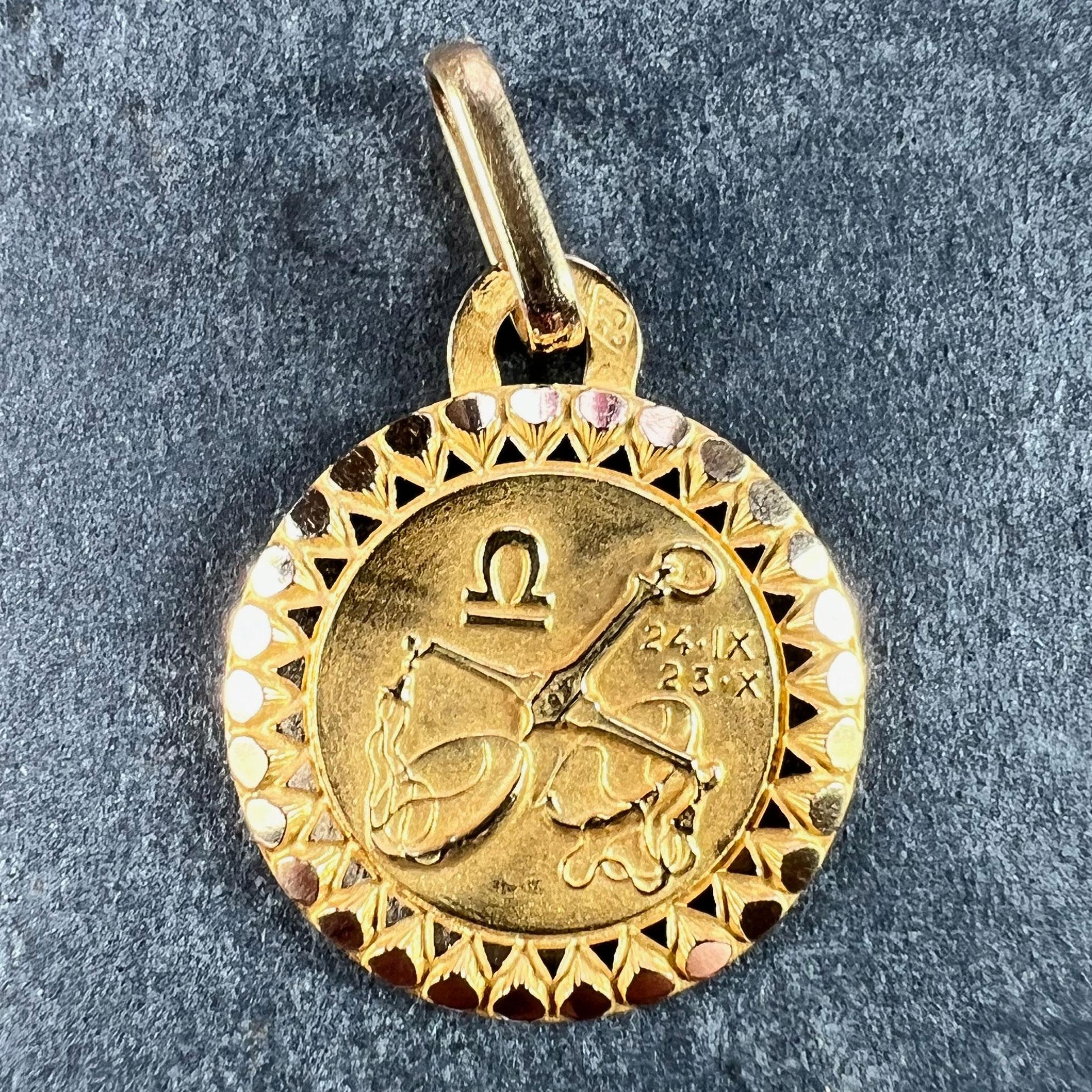 An 18 karat (18K) yellow gold charm pendant designed as the Zodiac sign of Libra, depicting a pair of scales with the dates 24 IX (September) and 23 X (October). Stamped with the eagle mark for 18 karat gold and French manufacture with maker's mark