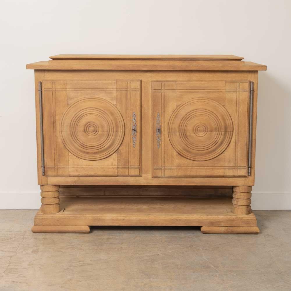 Splendida credenza in rovere chiaro di Charles Dudouyt, proveniente dalla Francia, anni '40. Dettaglio circolare intagliato su due ante con un ripiano interno. Due gambe intagliate e un ripiano di base basso che poggia su quattro piedi. Splendida