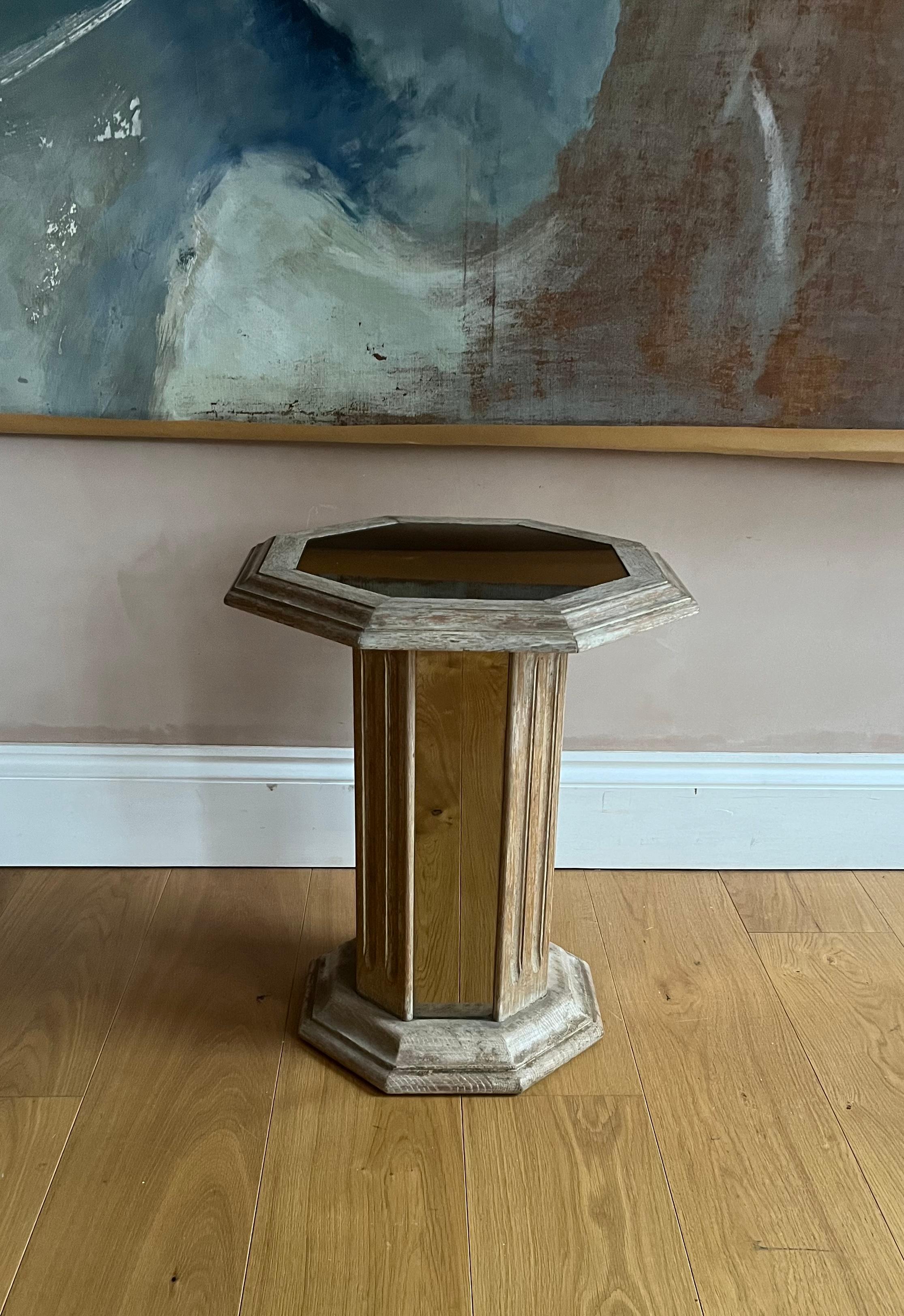 A French limed oak and tinted mirrored pedestal side table.