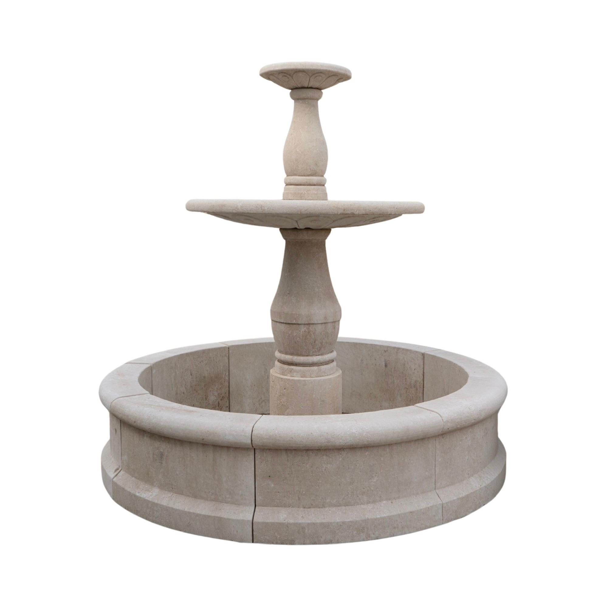 Cette fontaine centrale en pierre calcaire française ajoute une touche d'élégance française à tout espace extérieur. Le design à deux niveaux présente des sculptures complexes, et le matériau calcaire durable garantit une beauté durable. Le style