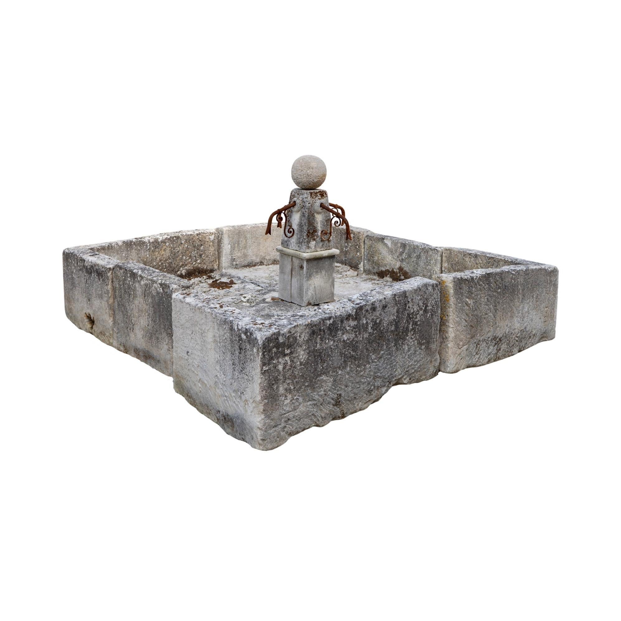 This antique French limestone central fountain from the 17th century is the perfect addition to any outdoor space. With a square shape and a central style design, it features a pillar with 4 spouts and overflow drainage openings for a classic look.