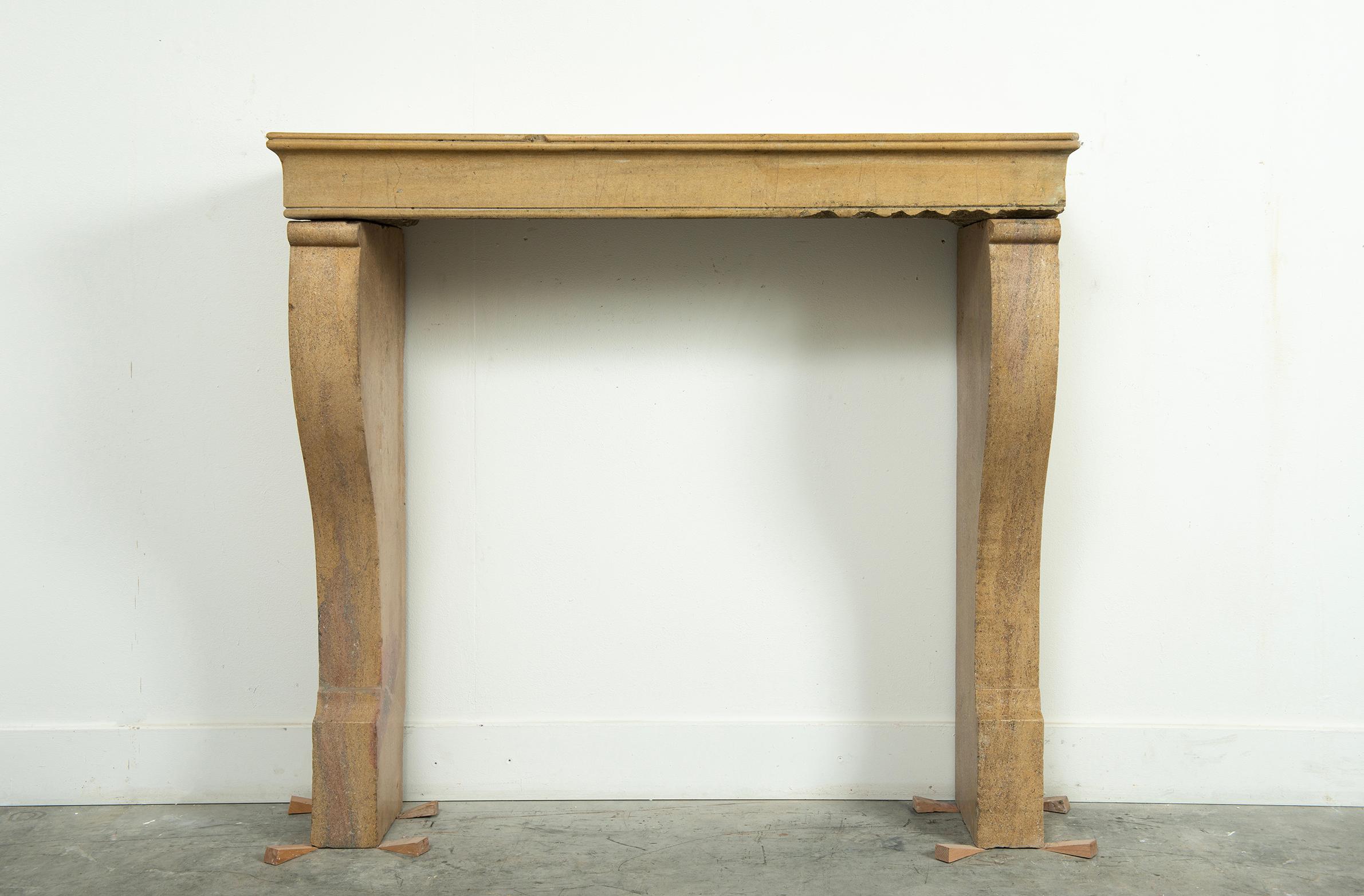 Bring a touch of timeless French elegance to your interior with this limestone fireplace mantel. Sourced from a historic French estate, this stunning piece embodies classic European craftsmanship with its graceful curved legs and subtly detailed