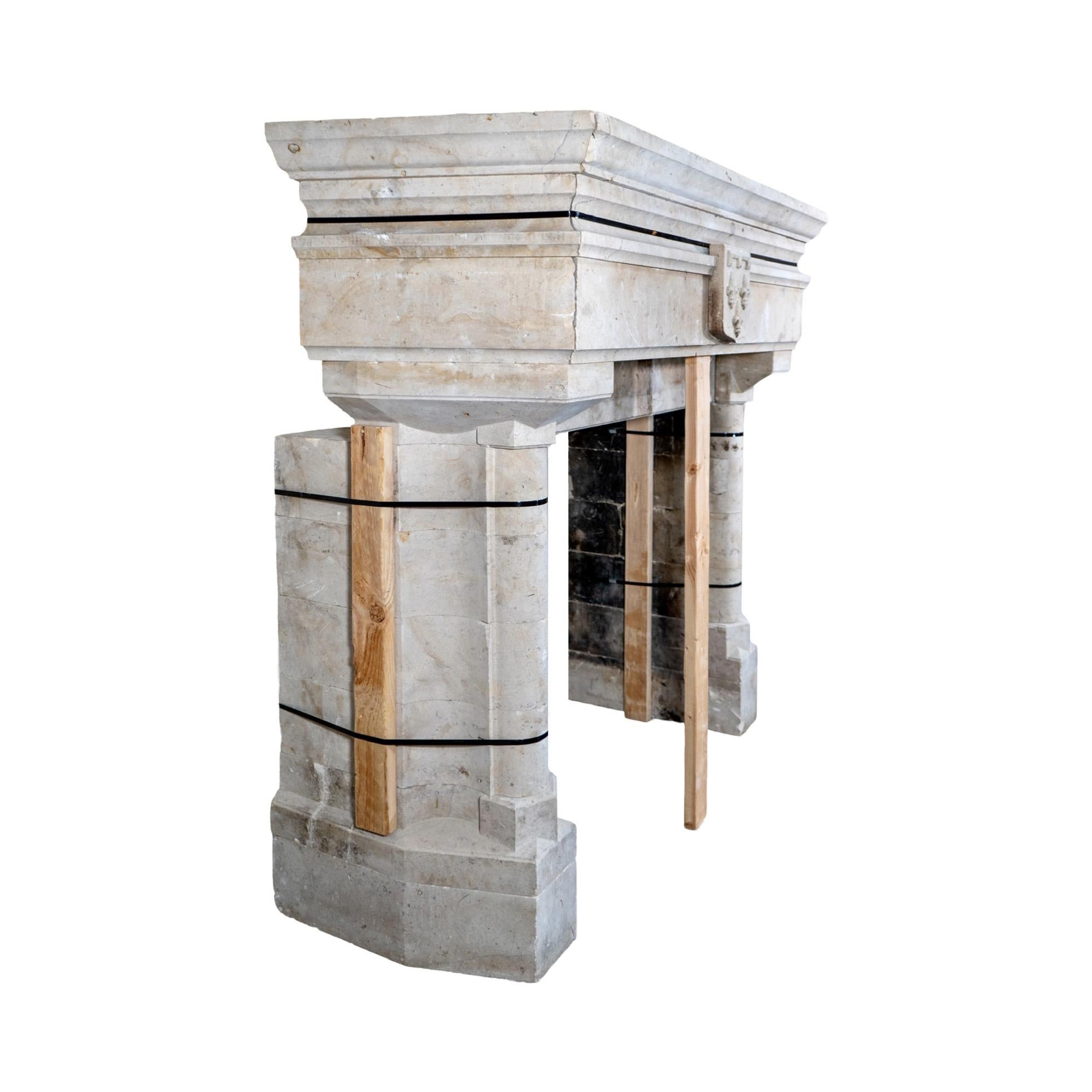 The French Limestone Mantel features a beautifully carved fleur de lis emblem and dates back to the 19th century. Expertly crafted from authentic limestone imported from France, this mantel adds elegance and sophistication to any room while also