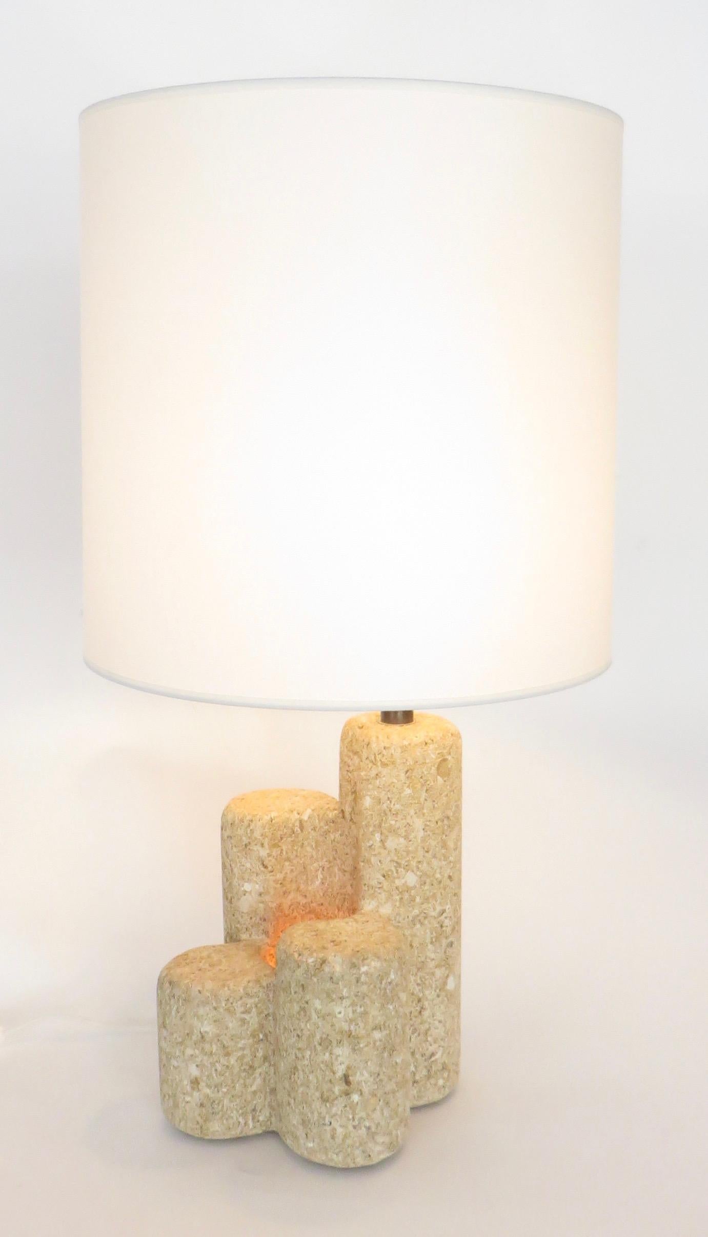 French limestone table lamp in the style of Albert Tormos. Unsigned.
This table lamp has four columns of french limestone or buffa with one internal light and one light at the top of the lamp.
The French lampshade is offset asymmetrically to