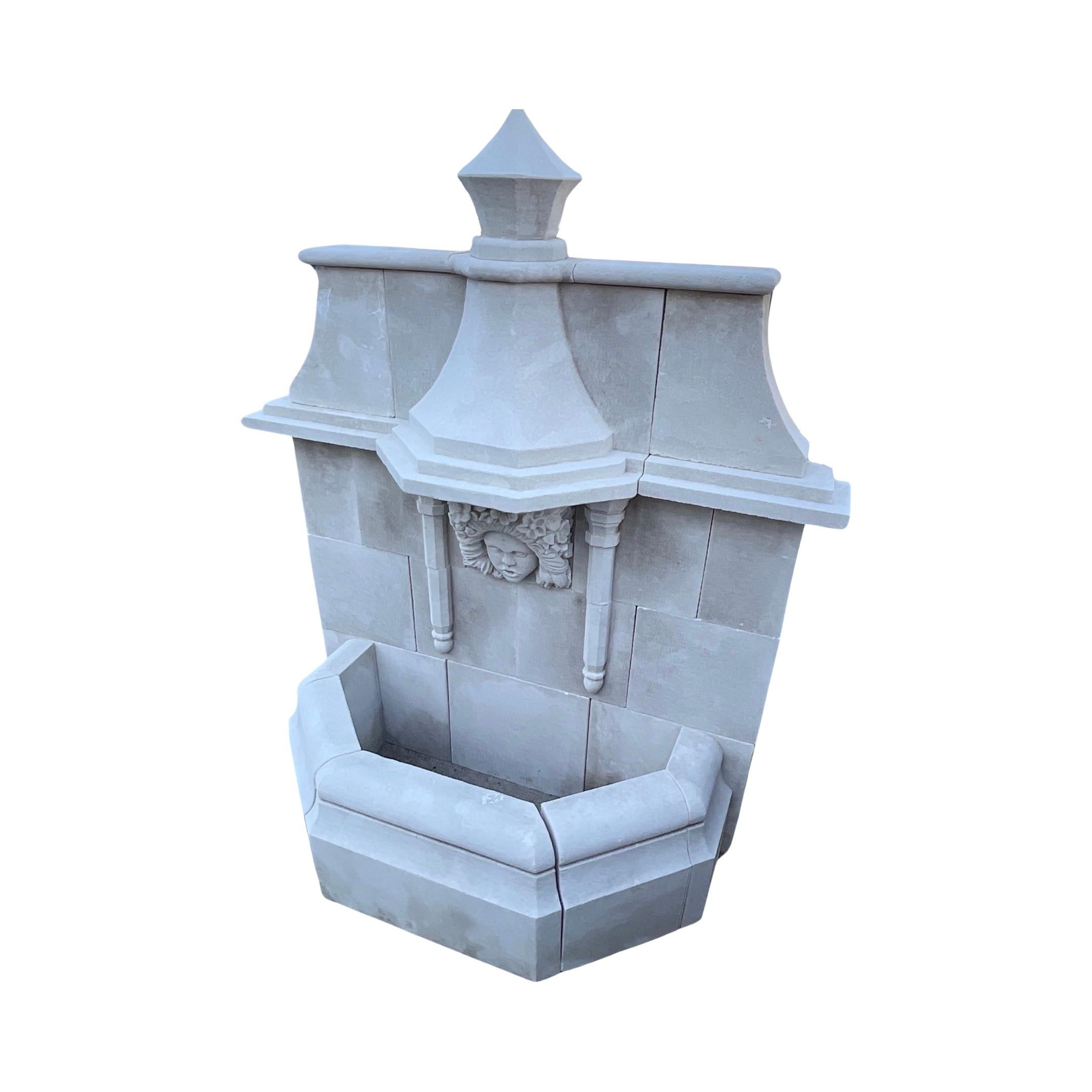 This elegant French Limestone Wall Fountain is the perfect accent to any outdoor or indoor space. Crafted from authentic limestone, this contemporary fountain features a low line basin and a carved figure face with floral motifs, allowing for a