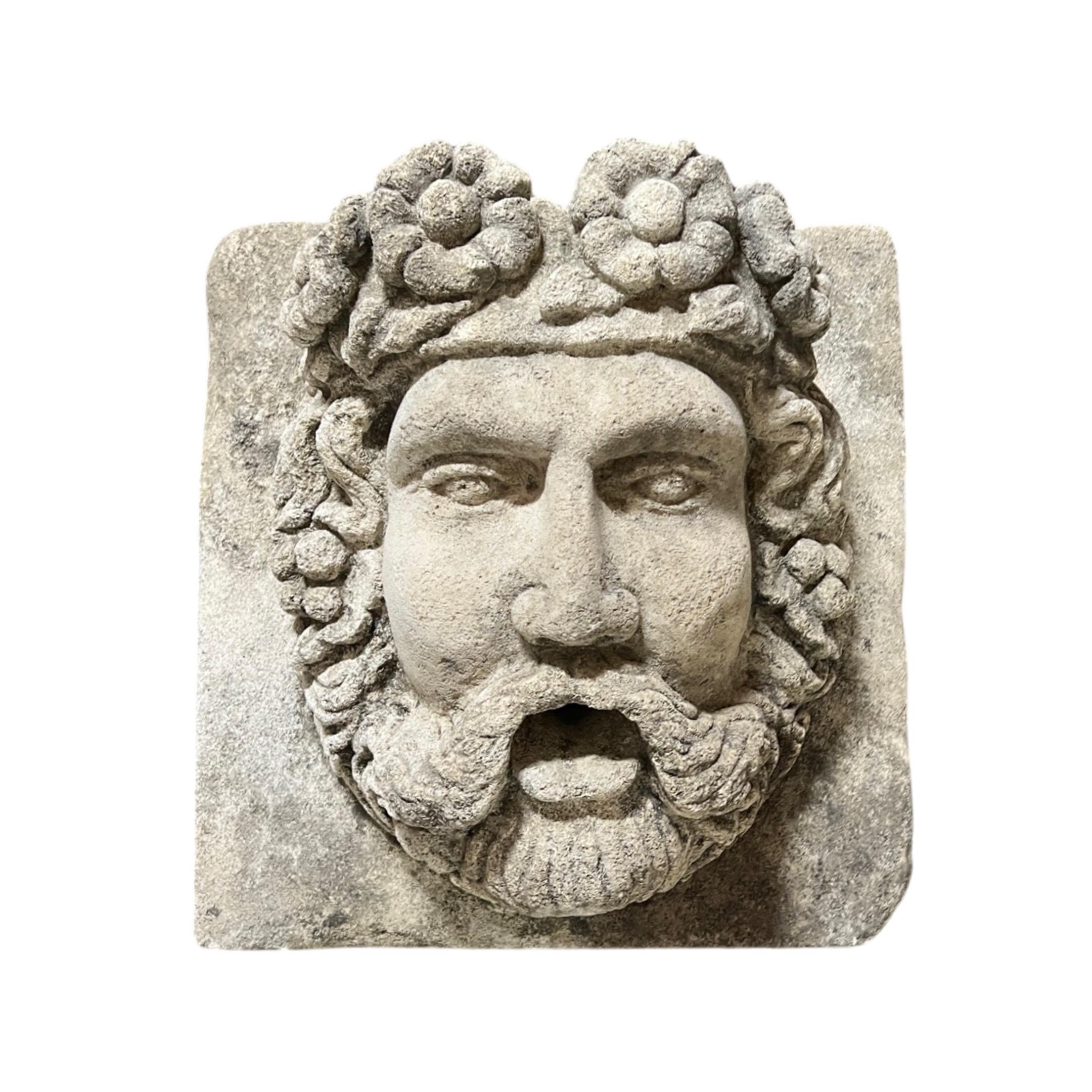 Water exit made of limestone. Hand-carved image depicts a God, Bacchus.