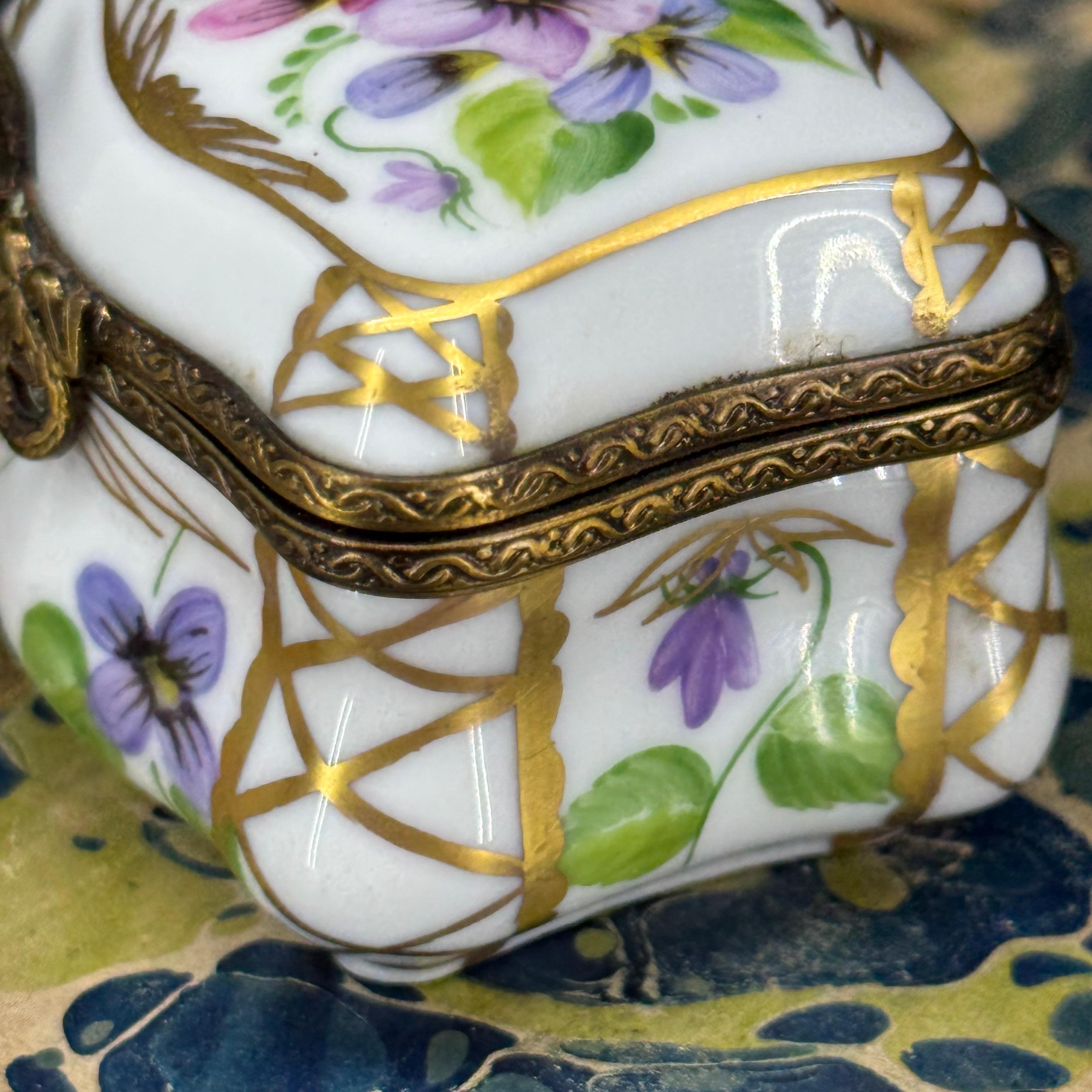 Encantadora caja de baratijas de porcelana de Limoges pintada en rosas, morados y verdes. Al abrir la caja, también hay un bonito diseño floral en el interior. La caja lleva la marca Peint Main Limoges Francia. Esta pieza sería sin duda una