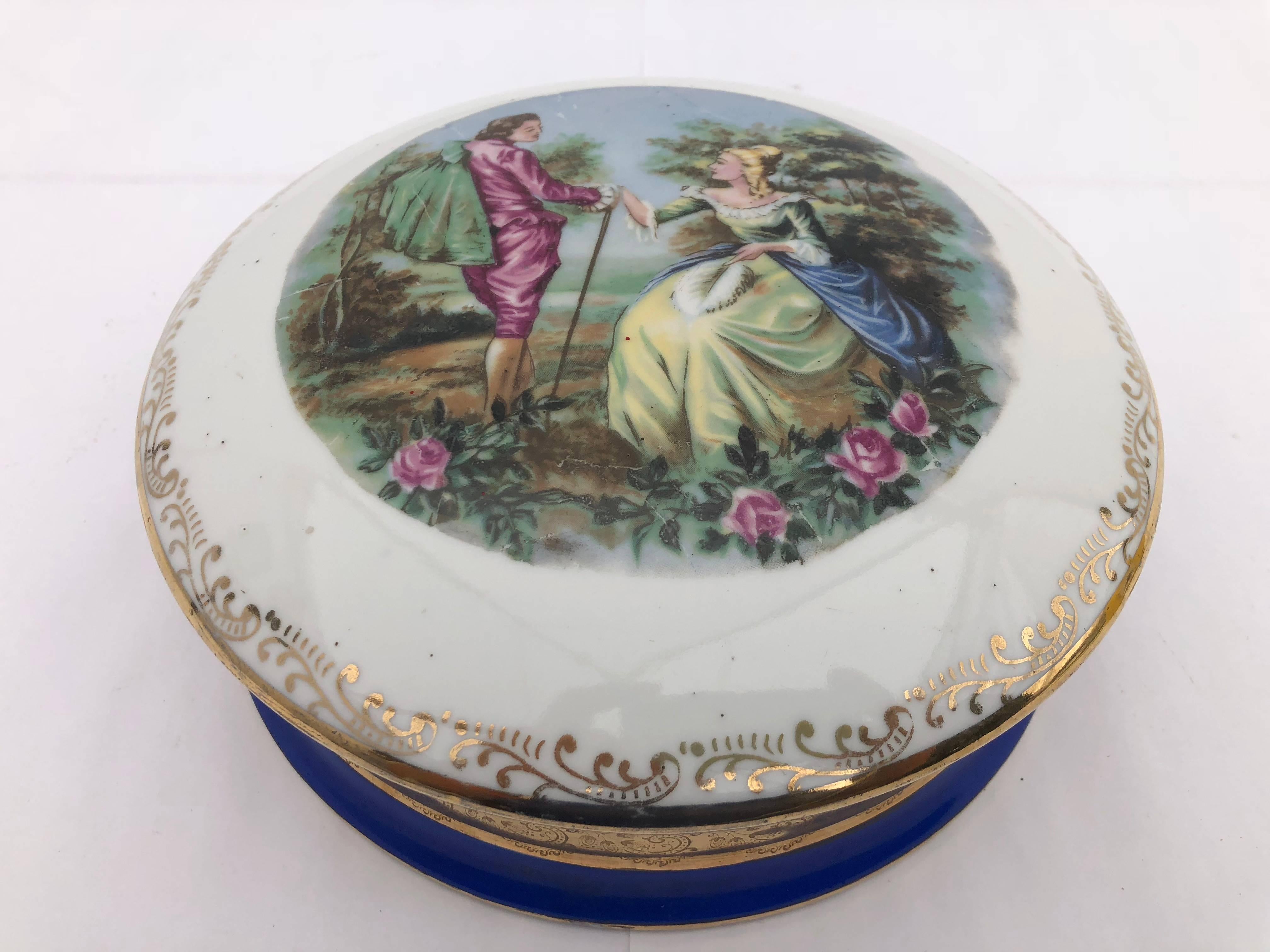 This is a lovely French Limoges porcelain candy box with royal blue and gold trim, featuring a romantic scene inspired by Fragonard's paintings. These porcelain boxes used to be offered as a gift filled with candies or sugared almonds (dragées).