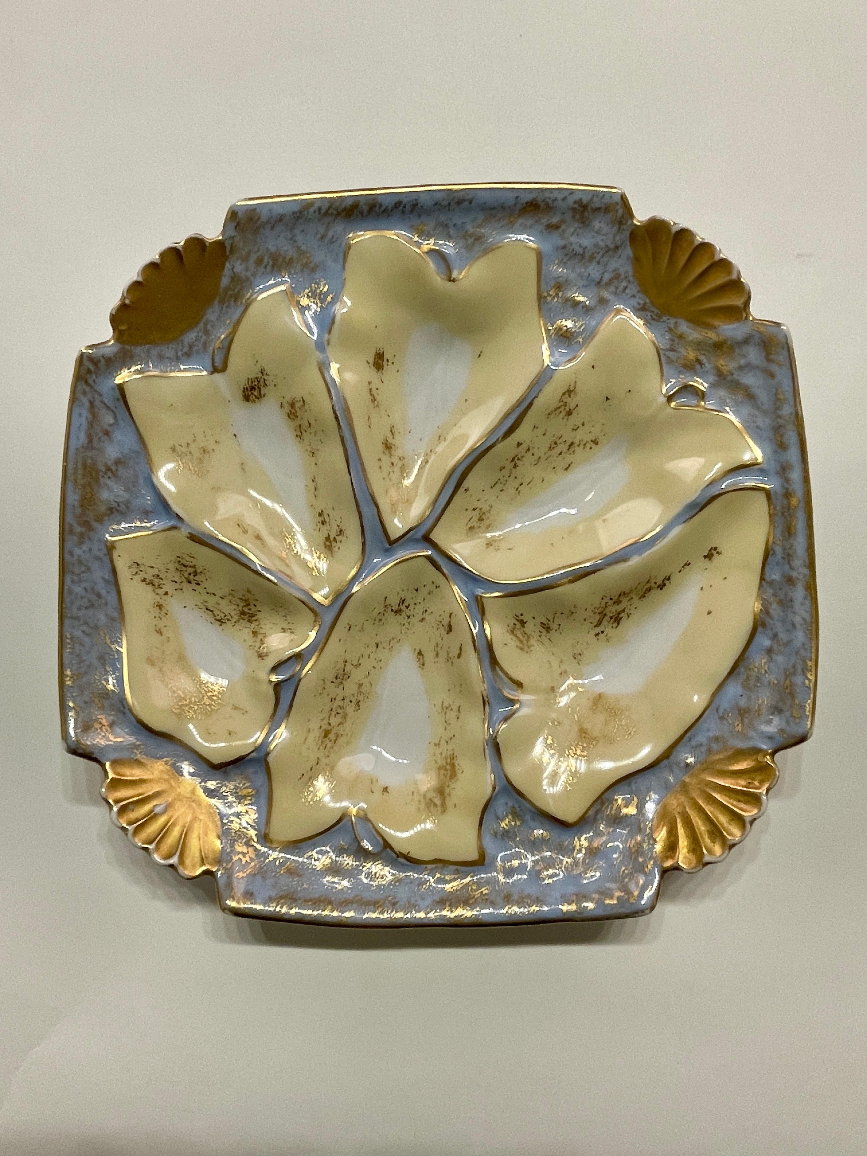 Une bonne assiette à huîtres en porcelaine de Limoges de couleur bleu pâle et jaune entourée de feuilles d'or. En très bon état, sans ébréchures ni traces de cheveux. La plaque est carrée de 8,25 pouces et haute de 1,25 pouce. Circa 1880-1900. #