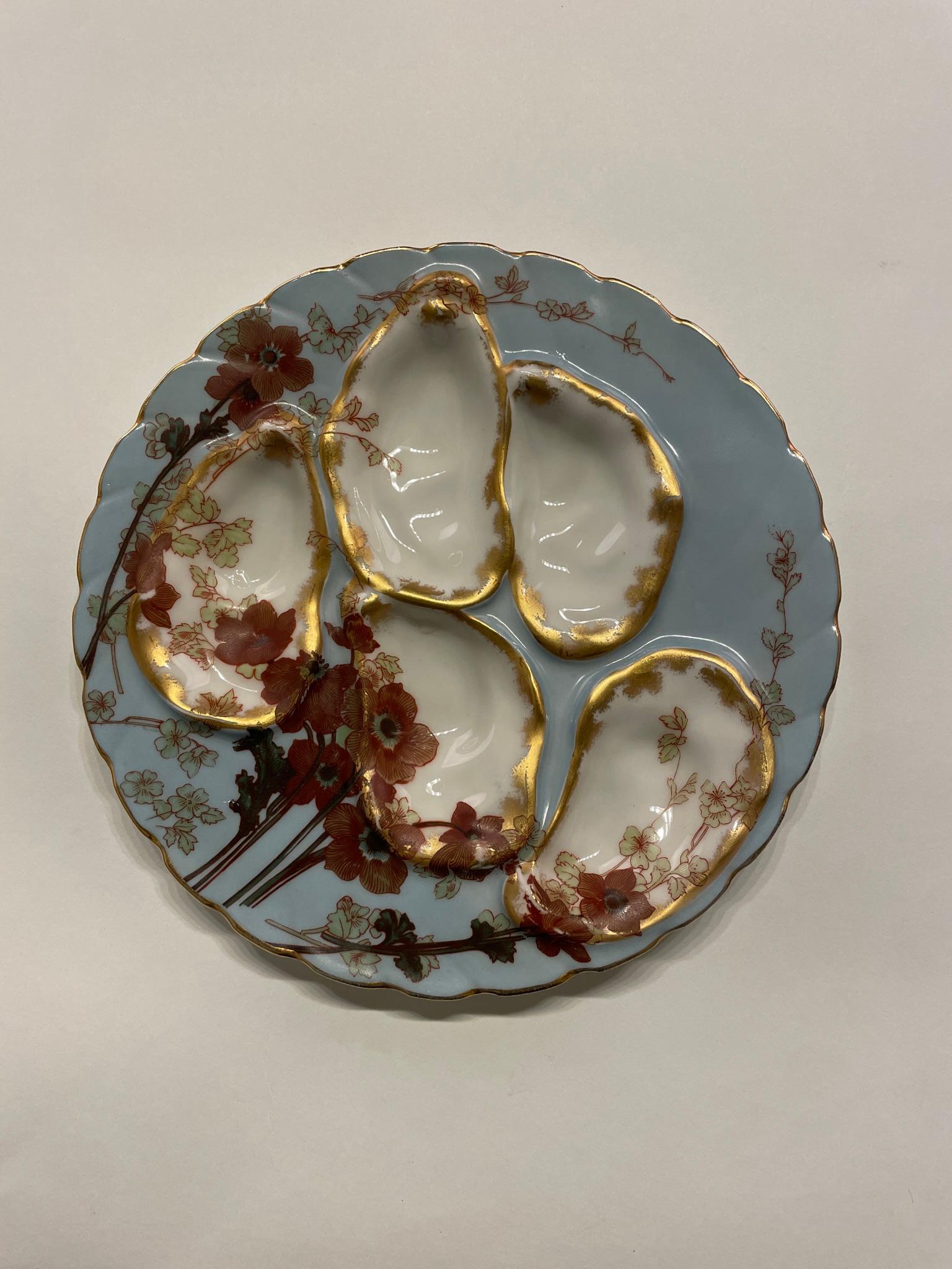 A fine Porcelain Oyster plate with gilded decor on a pale blue background. Stamped on the back Wright Tyndale & Van Roden in Philadelphia. Great condition. Dimensions are 7.75