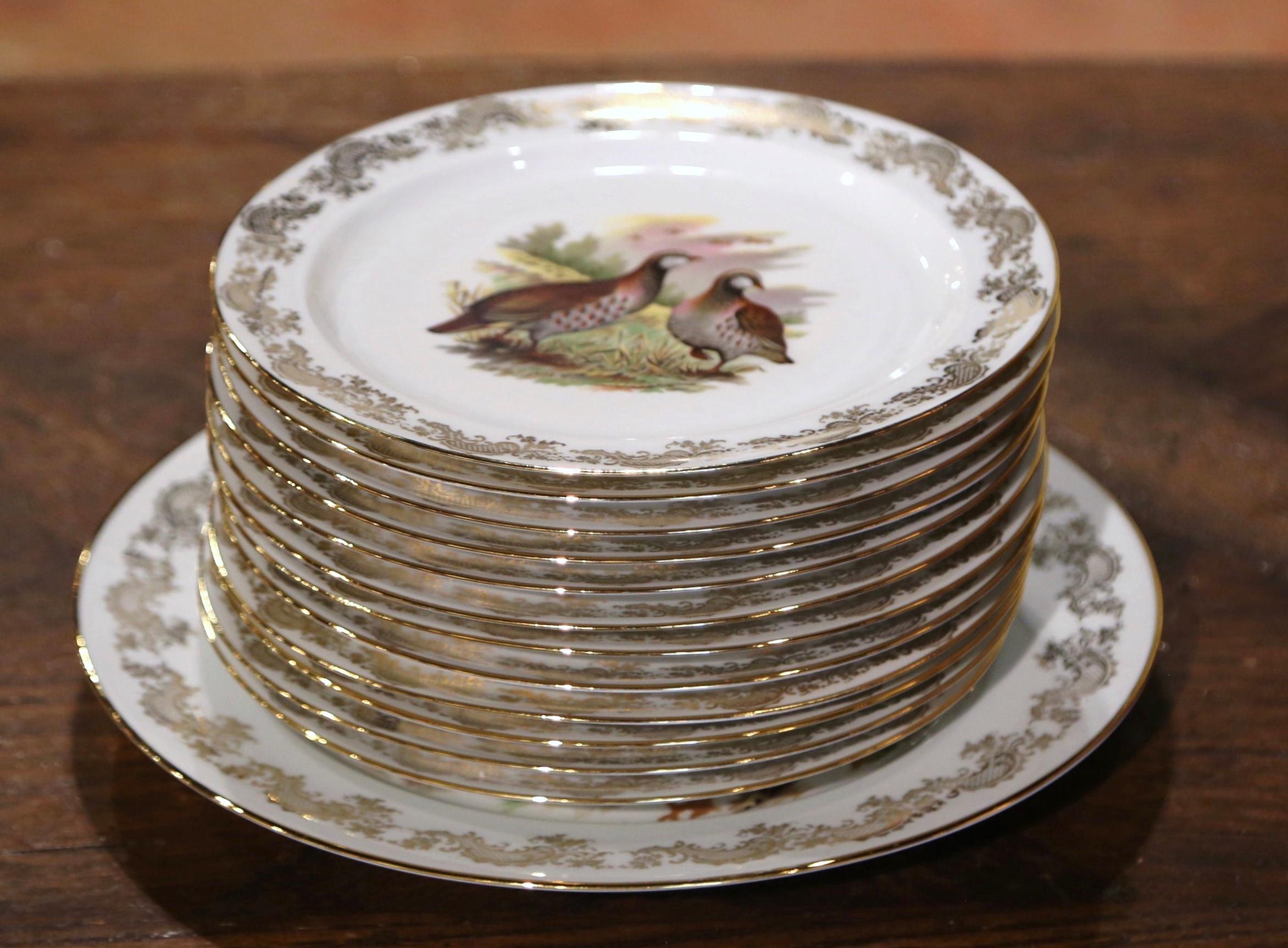 Decorate a vaisselier or a shelf with this colorful set of twelve (12) porcelain plates and the matching platter. Crafted in Limoges France, and signed underfoot by the artist, Benoit, each piece is decorated with gilt floral lace border, and