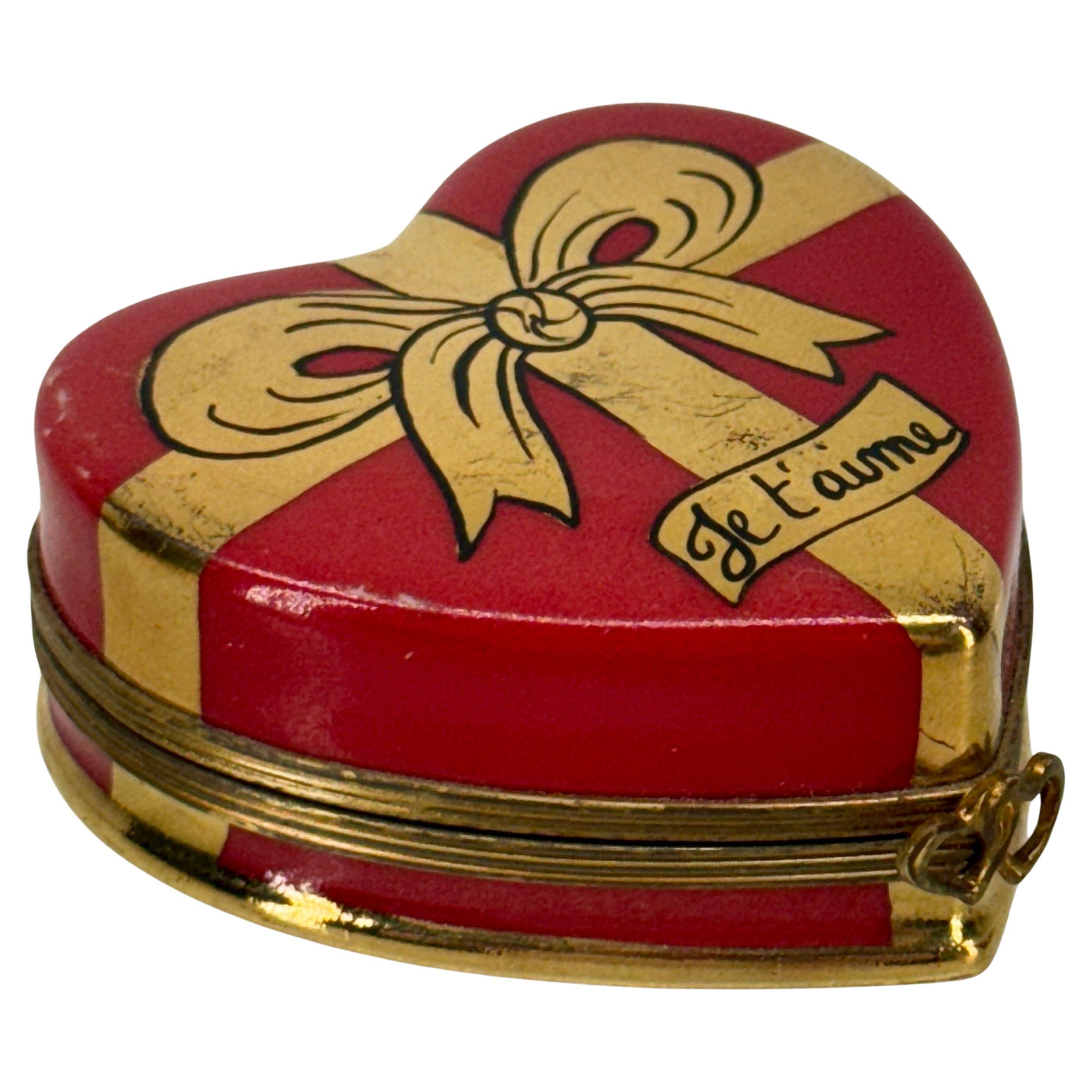 Charmante boîte à bibelots en forme de cœur rouge de Limoges avec ruban et nœud en or 22KT. Une banderole portant l'inscription 