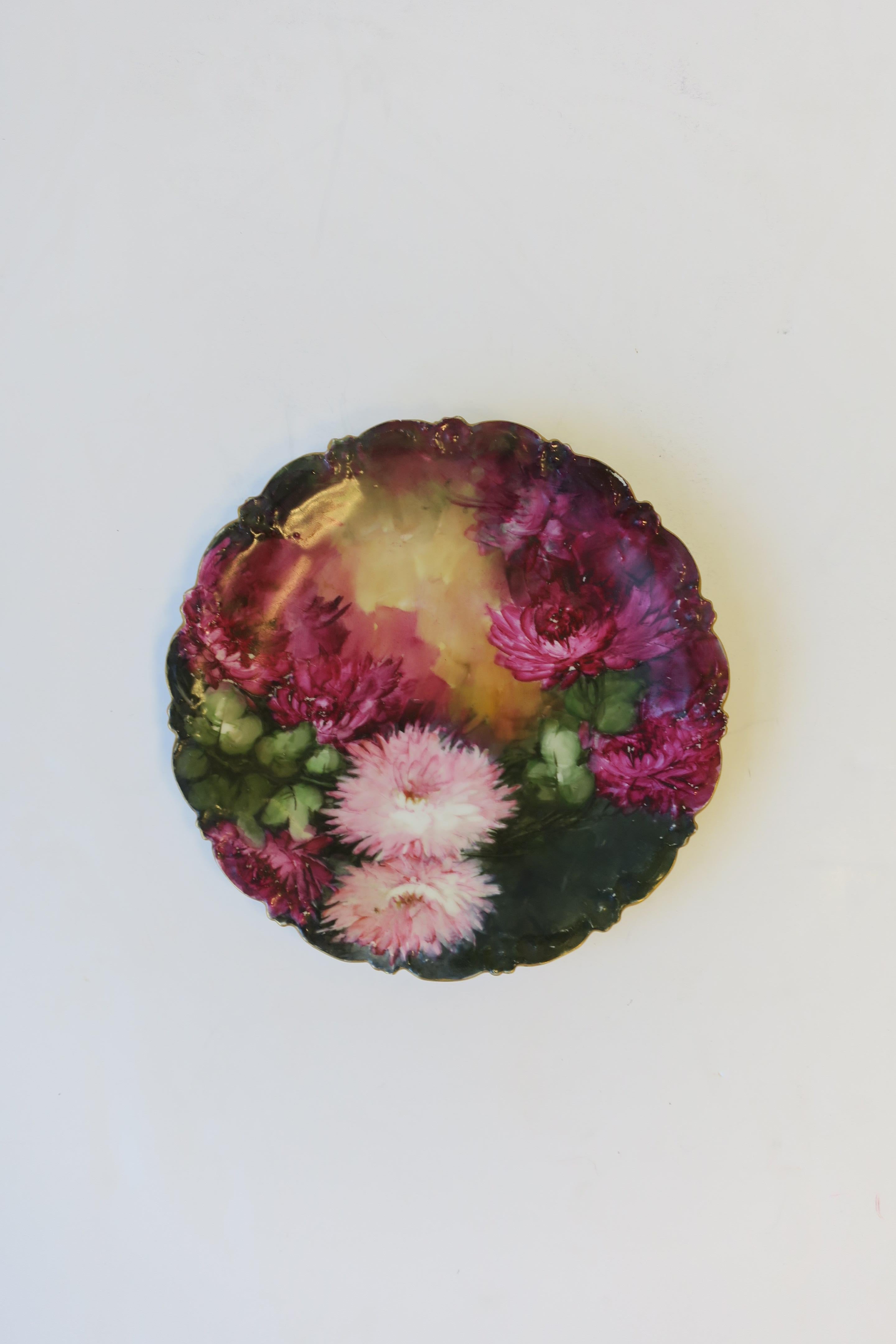 An early-20th century French hand-painted plate by T & V, Limoges, France. Plates' design is beautiful fuchsia-purple and pink mum flowers and green leaves, finished with a gold gilt scalloped edge. Maker's mark on bottom as show in last image.