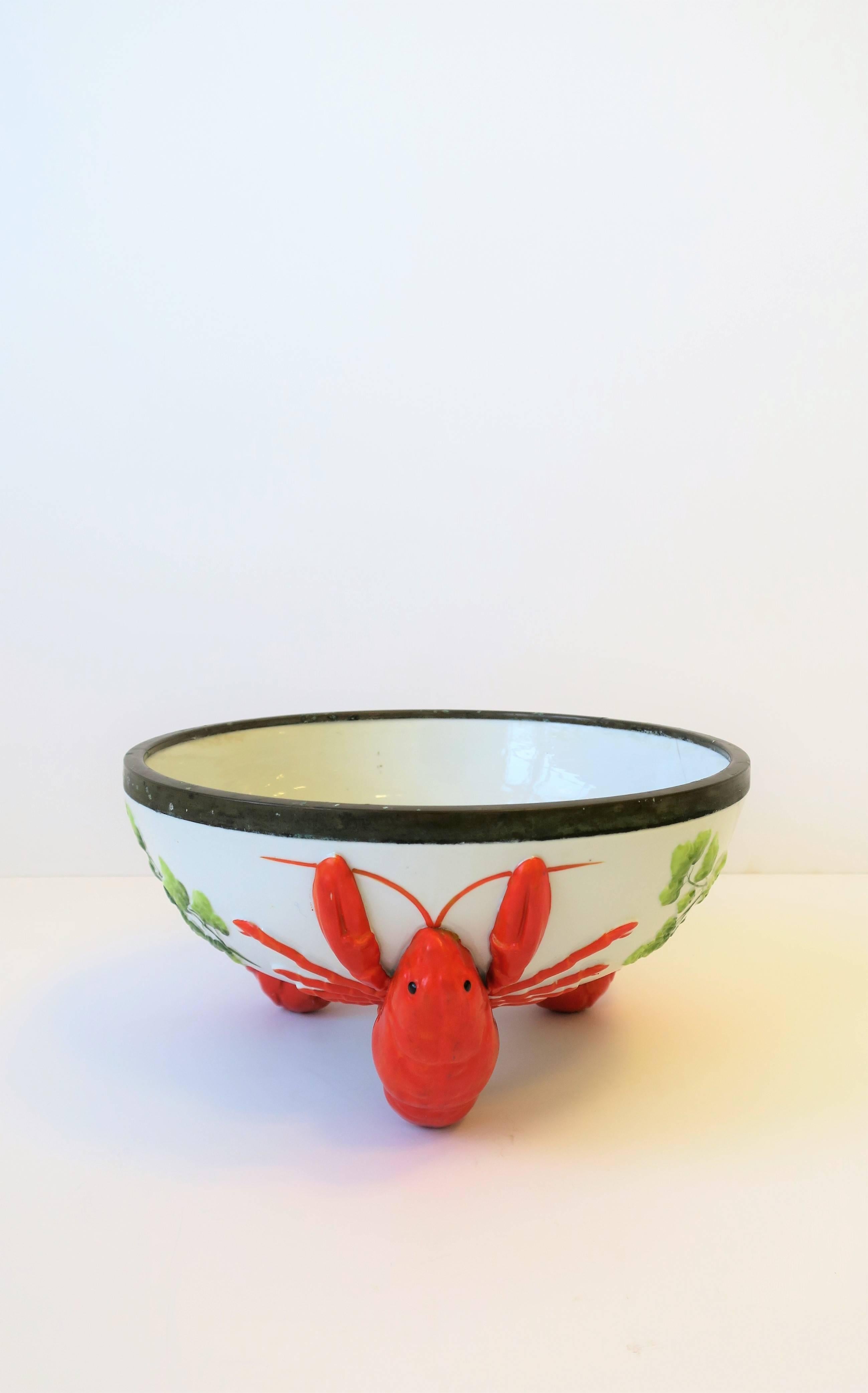 A beautiful vintage French Limoges Majolica style lobster decorated serving bowl with brass rim, circa Mid-20th century, France. Brass rim serves as a protective barrier to the ceramic bowl edge. This brass rim has a beautiful patina as show in