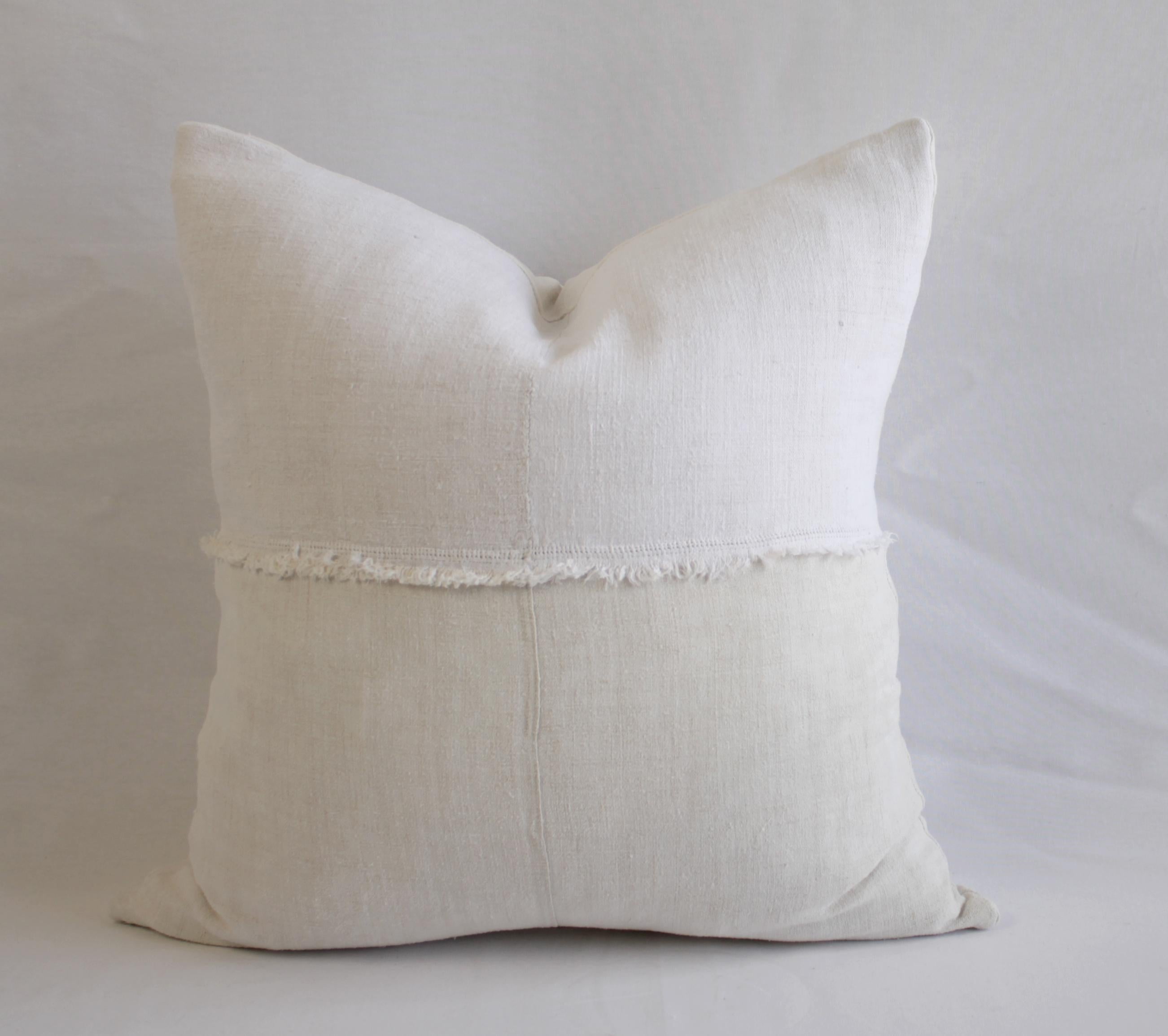 French linen pillow in off white with fray details.
Made from 19th century French linens. This is a two tone off white, the top portion is a soft white, the bottom face is a creamy white. The fray detail is original to the linen we found, there is