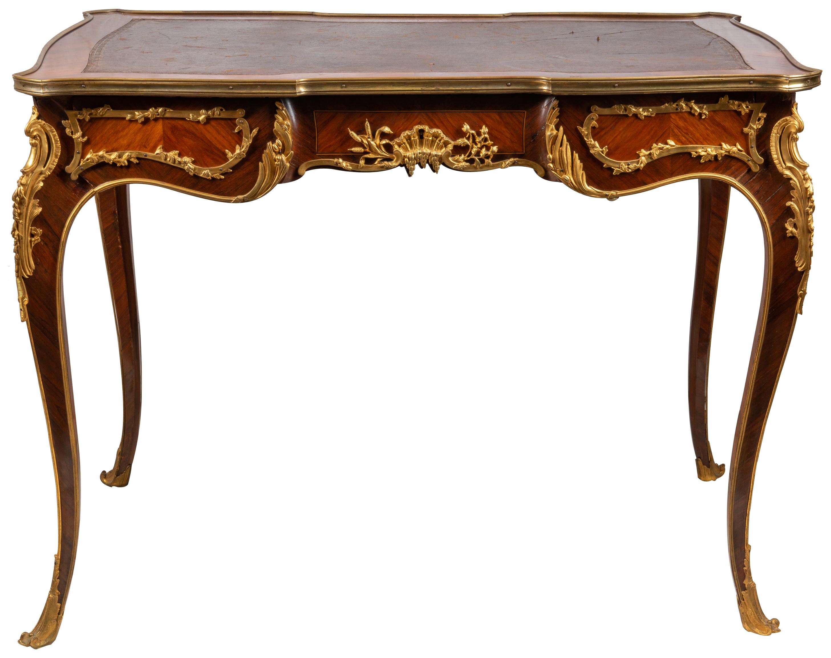 Un très bon bureau plat en acajou de style Louis XVI de la fin du 19ème siècle, à la manière de Françoise Linke. Il présente un plateau en cuir, des moulures en bronze doré, trois tiroirs en frise avec des tiroirs factices au dos, de magnifiques