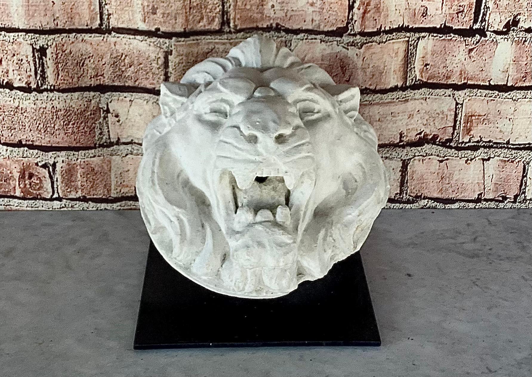 Scultura di testa di fontana con maschera di leone francese, montata su supporto di ferro. La testa di leone è molto curata nei dettagli e presenta una criniera fluente. Di colore bianco con una patina favolosa. Ha un gancio sul retro per essere