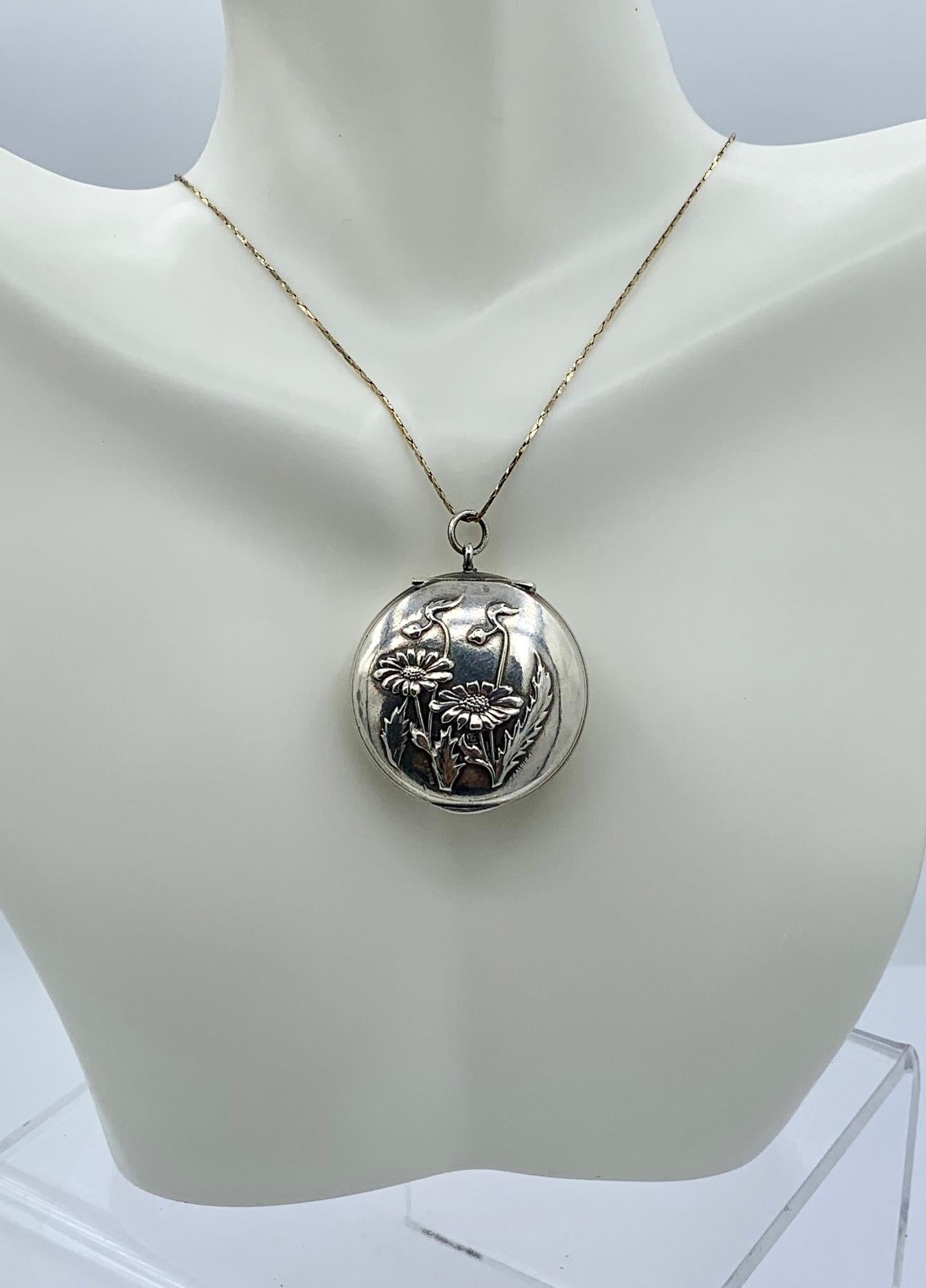 THIS IS A GORGEOUS FRENCH ART NOUVEAU LOCKET PENDANT IN SILVER WITH A BEAUTIFUL REPOUSSE DESIGN OF A FLOWER, LEAF AND BUD MOTIF.
This is just a stunning silver flower motif locket with exquisite Art Nouveau design of daisy flowers.  The reverse of