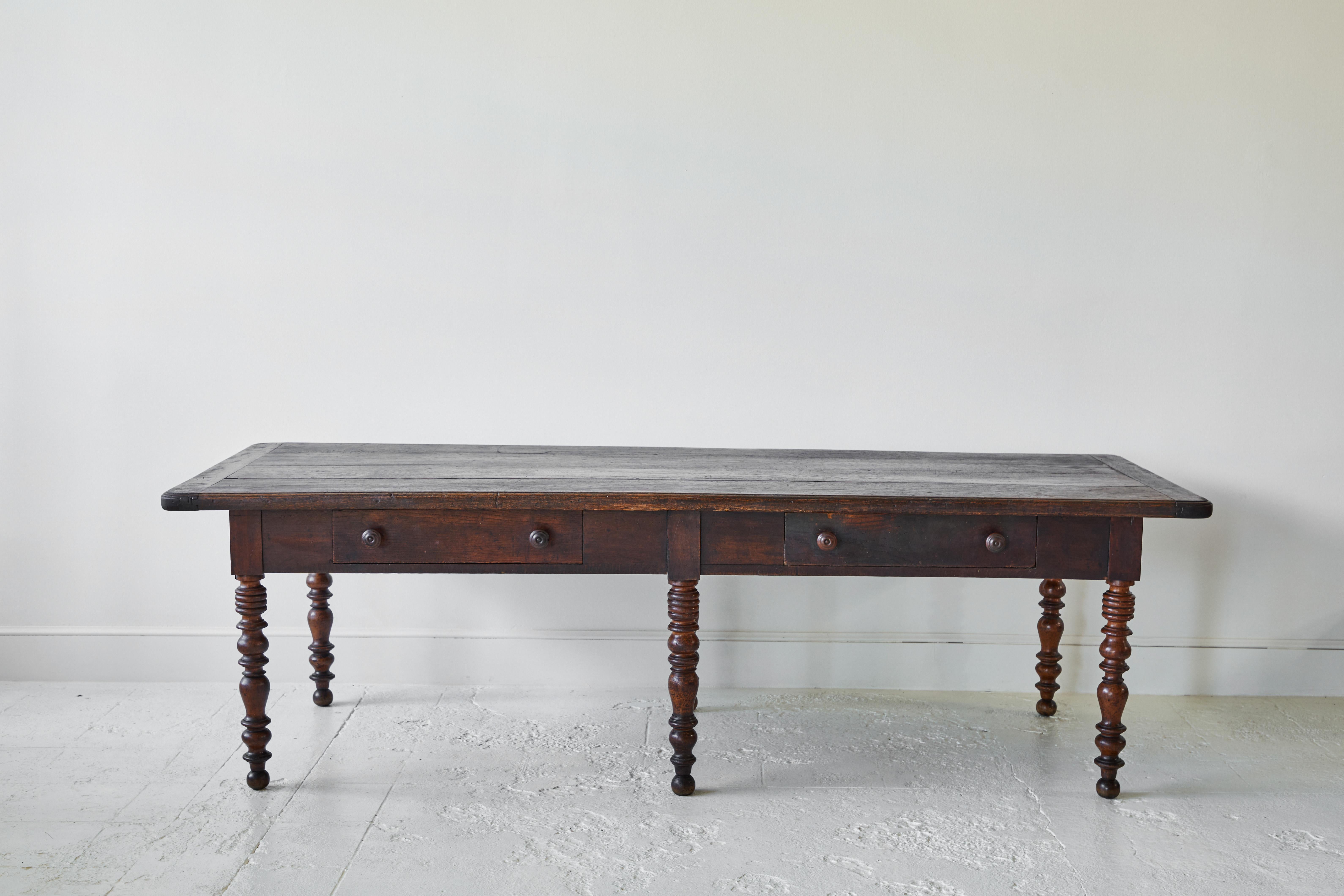 Beautifully crafted French table with six turned legs and two drawers on the side, the wood is beautifully stained.