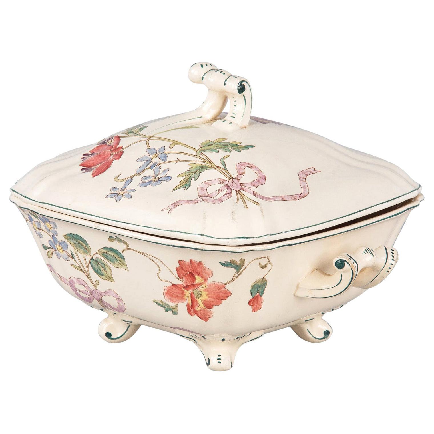 A vintage Longchamp ceramic tureen with hand painted flowers and ribbons. Raised on four scrolled feet, the faience piece has a square form with scrolled handles and a scrolled handle atop the lid. Both lid and tureen have subtly scalloped corners.