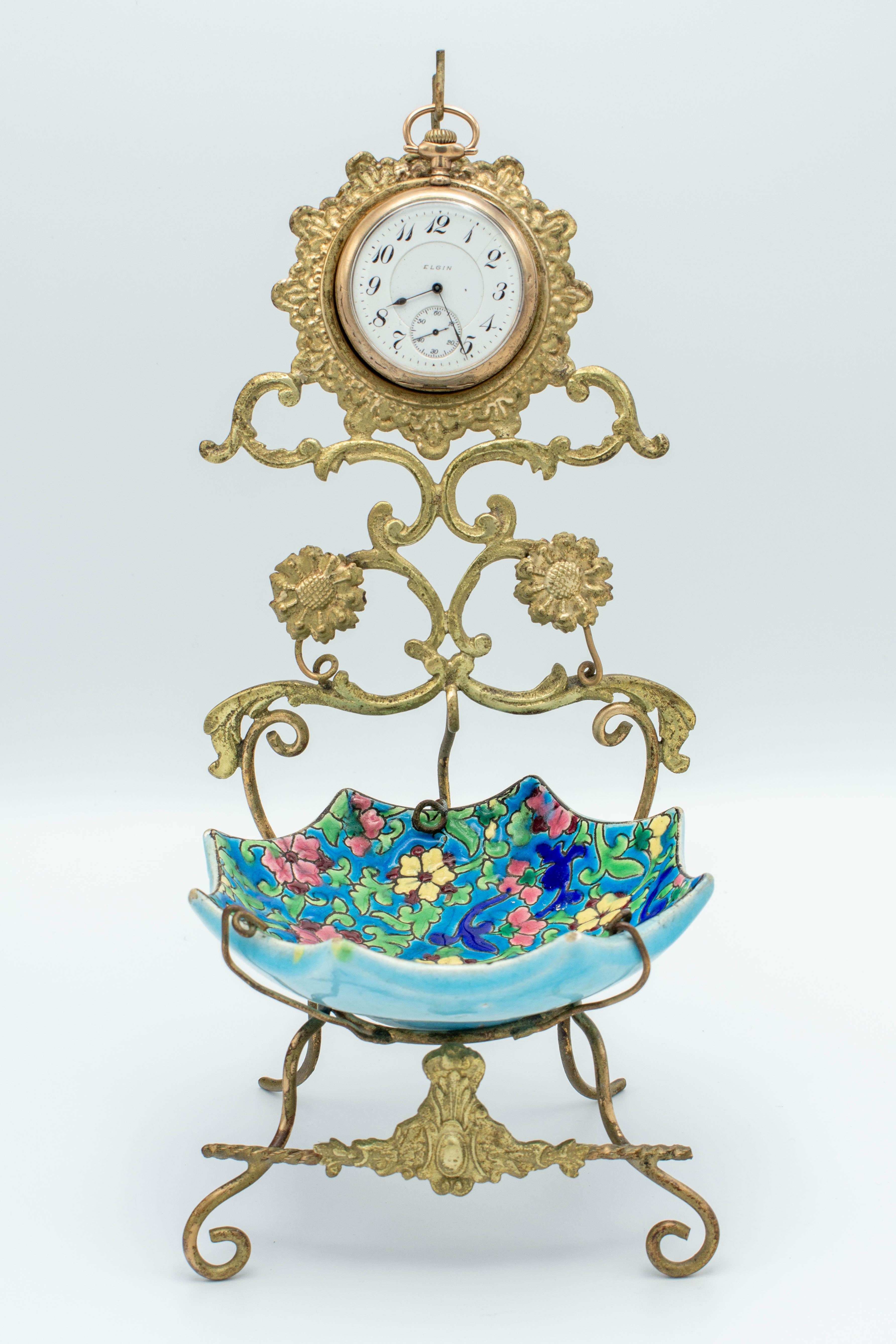 A French gilt metal pocket watch stand with Longwy faience dish to hold rings and jewelry. Beautiful cloisonné enamel floral design with vibrant colors. Watch is not included. Circa 1920-1930. In good condition.