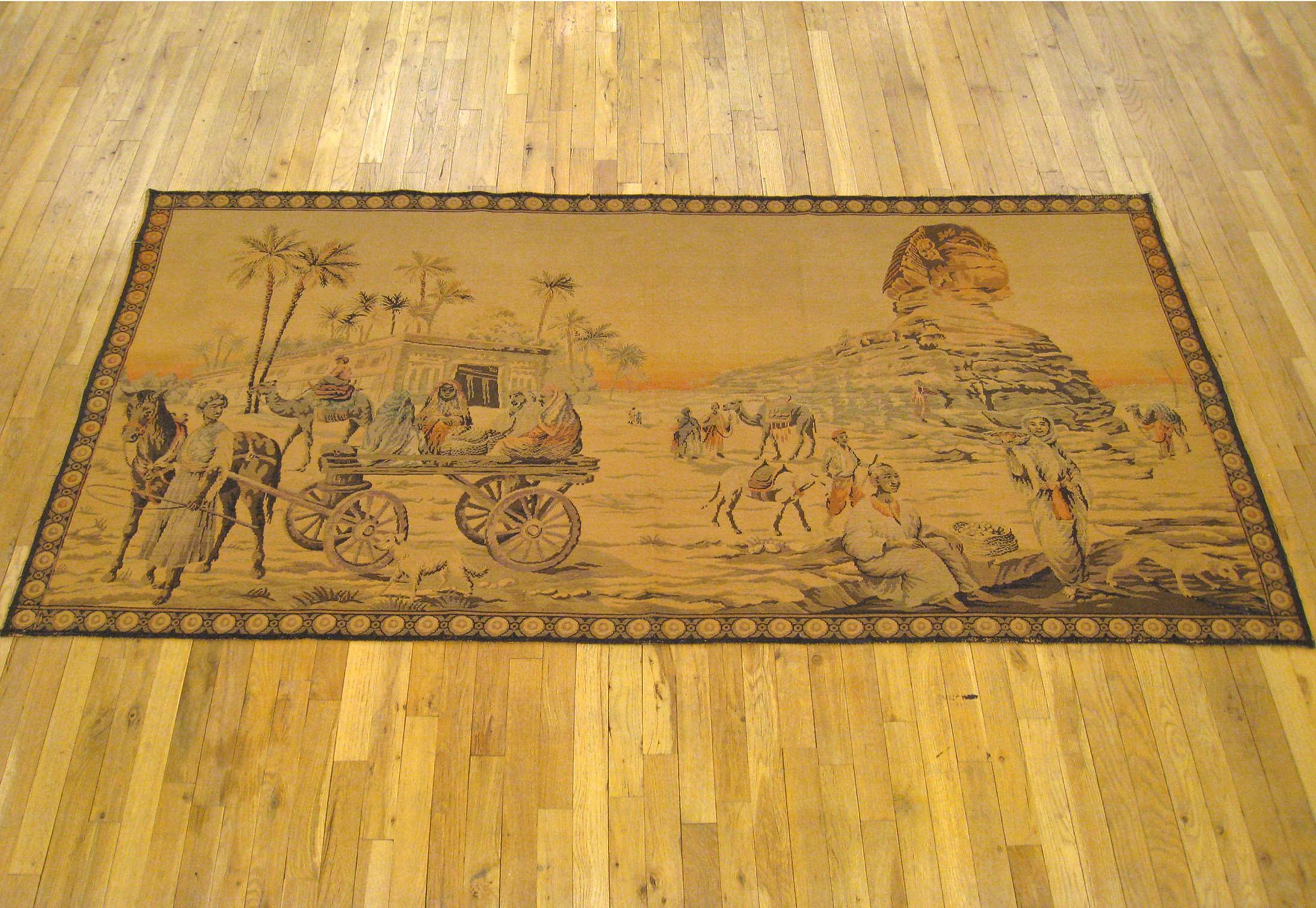 A French loomed Sphinx tapestry from circa 1900, portraying a desert scene with Egyptian locals carrying out their daily routines, but with the looming magnificence of the majestic Sphinx in the background as one of the cornerstones of their land