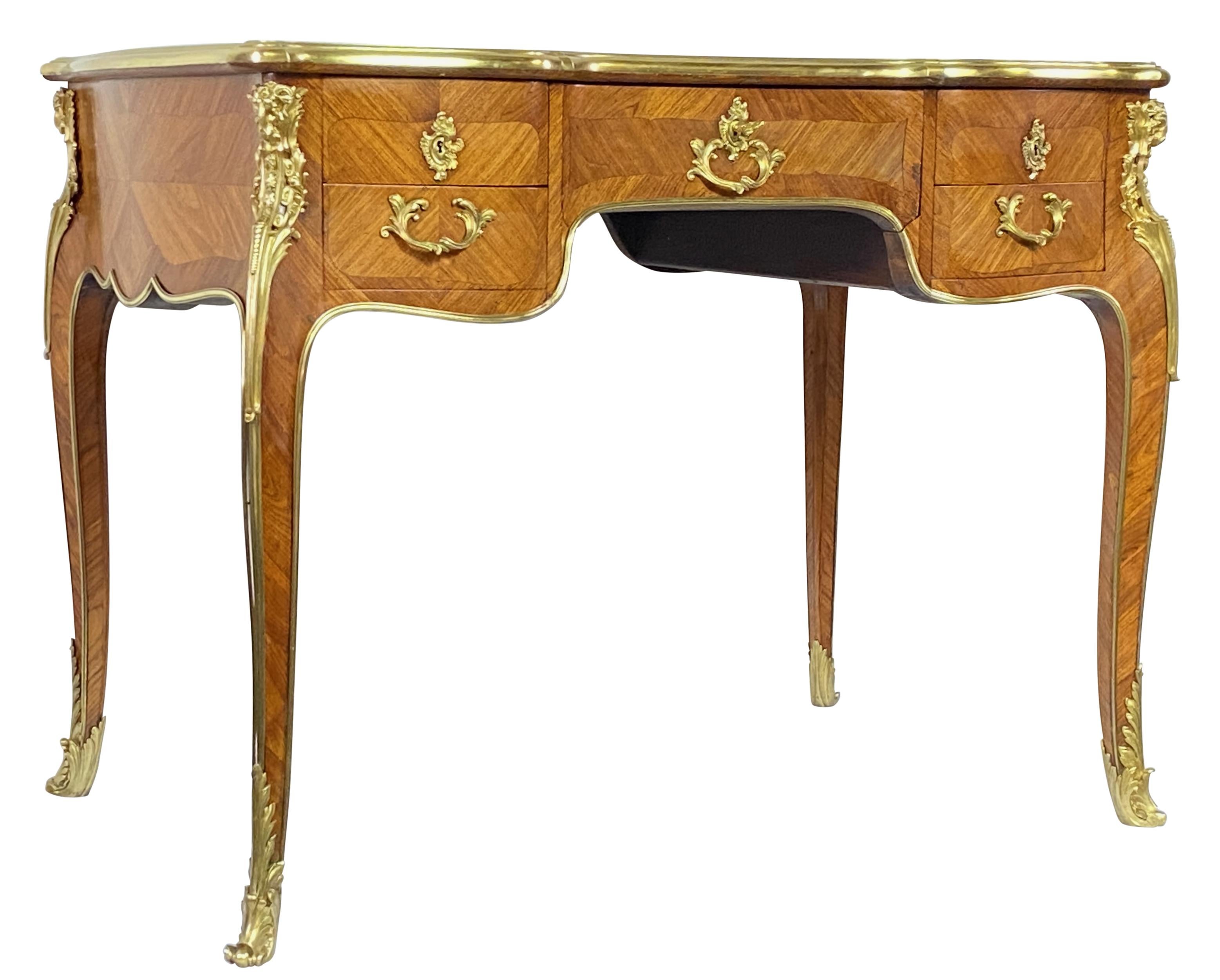Petit bureau de style Louis XV en noyer de très haute qualité, fabriqué à la main, avec de magnifiques ferrures en bronze moulé. 
Récemment rénové.
Nouveau support d'écriture en cuir toilé qui présente quelques regrettables défauts. Nous avons fixé