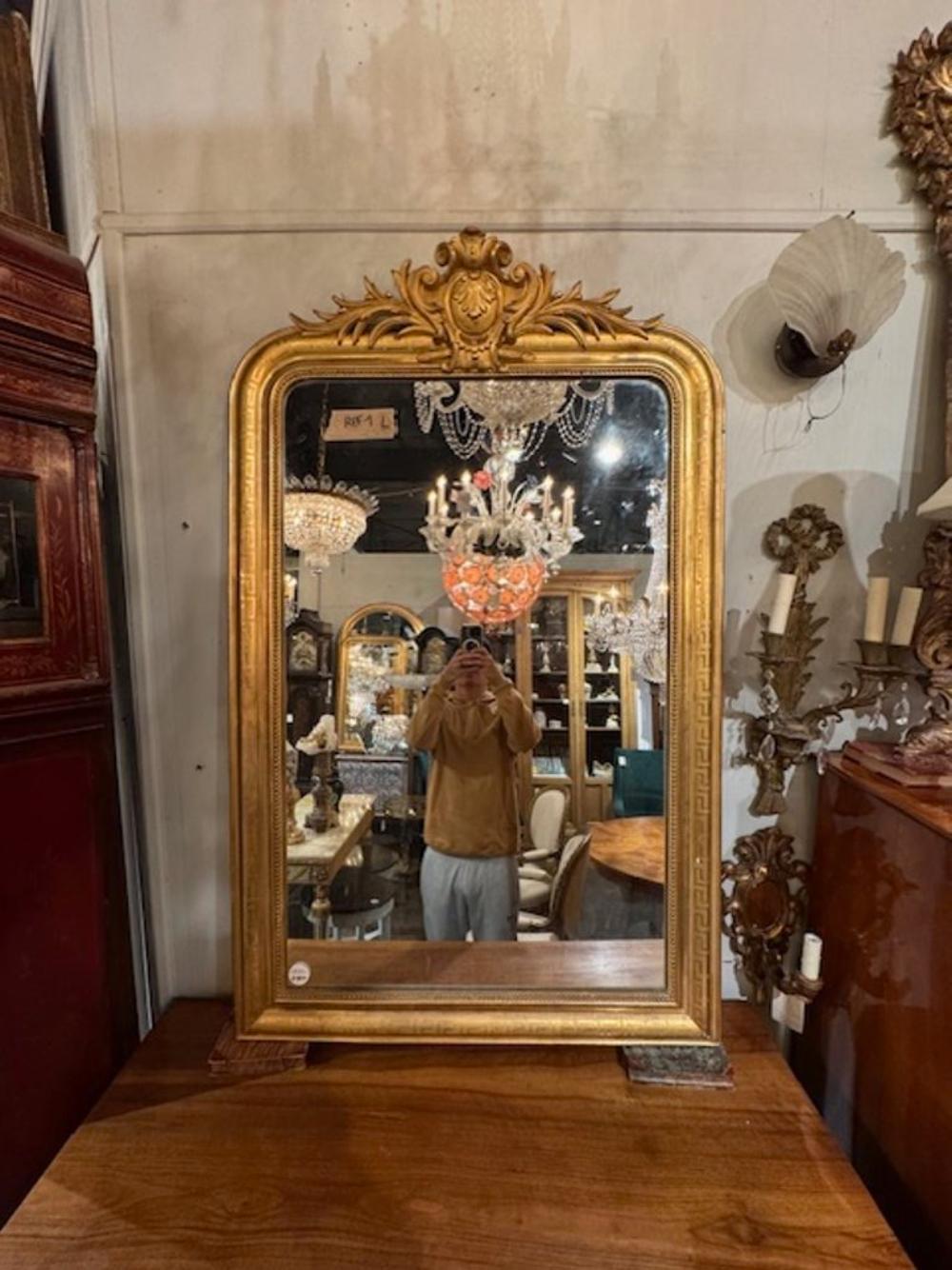 Bellissimo specchio a foglia d'oro francese Louis Philippe del XIX secolo con cornice con motivo a chiave greca e stemma. Circa 1870. Un tocco classico e senza tempo per un interno raffinato. 34L x 56H