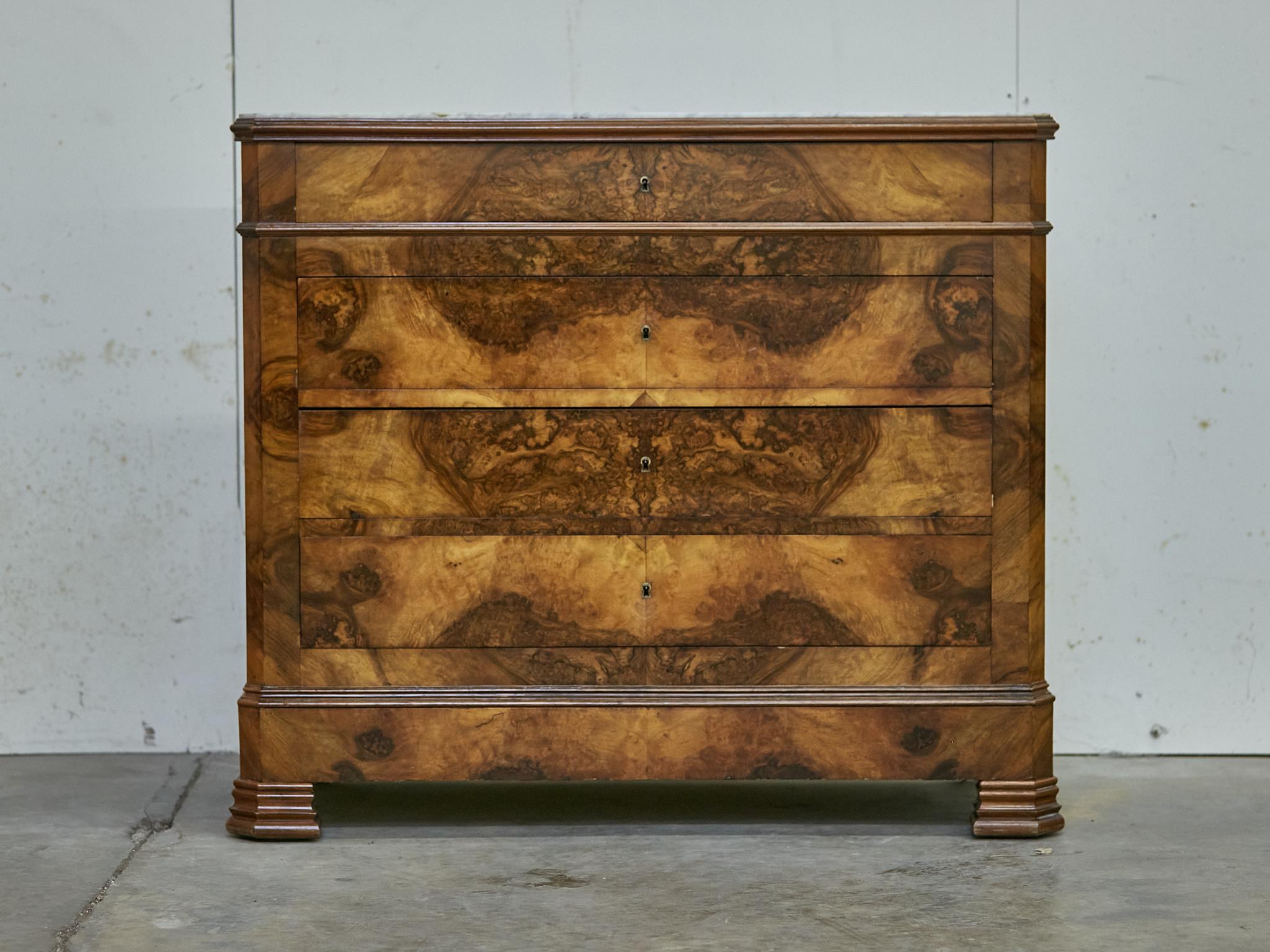 Commode francese a quattro cassetti in noce Louis Philippe del XIX secolo con decorazioni a libro e piano in marmo bianco. Prova l'eleganza e la maestria del XIX secolo con questa toilette francese a quattro cassetti in legno di noce Louis Philippe,