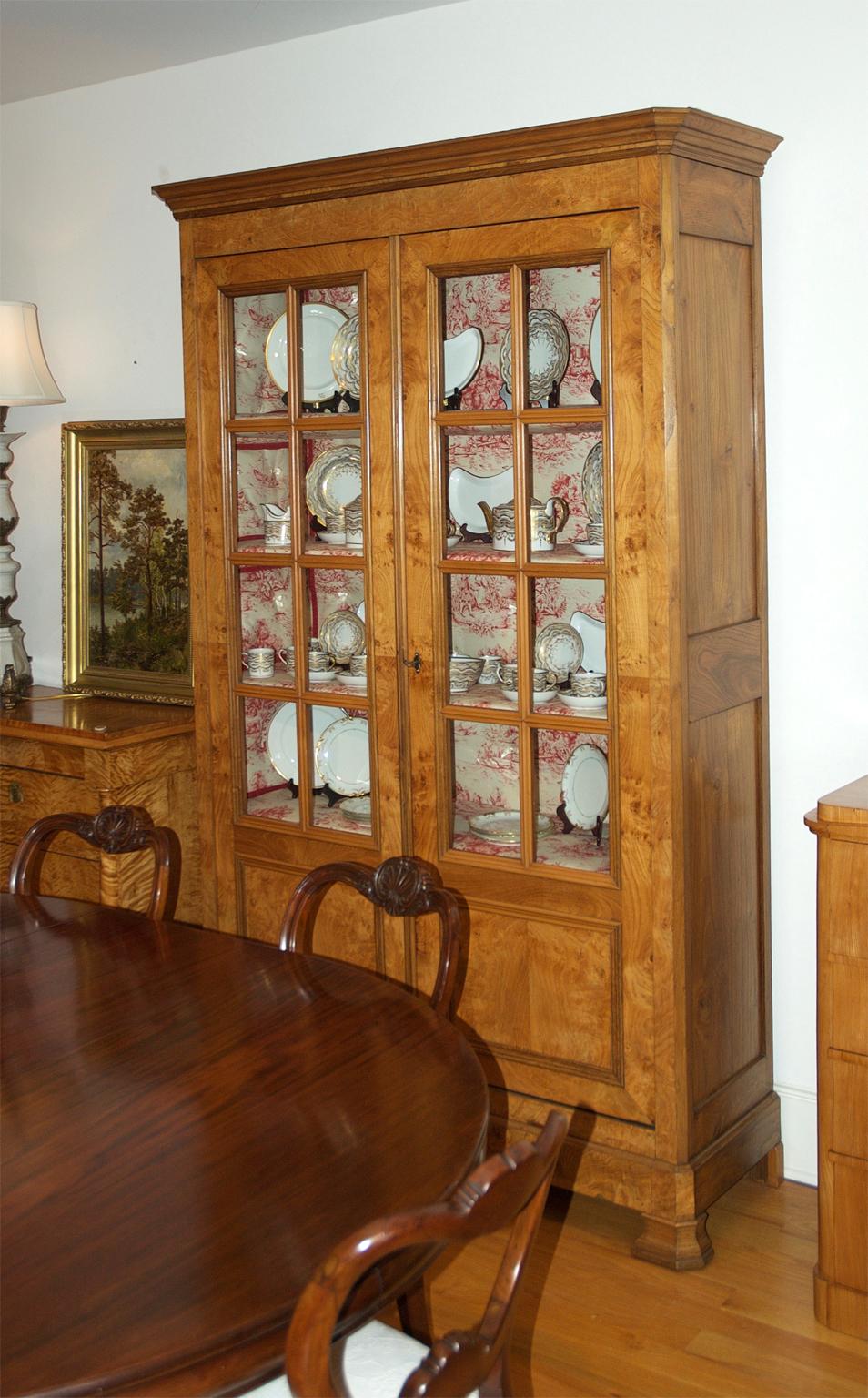 Très belle armoire ou bibliothèque Louis Philippe en châtaignier avec des panneaux de verre à meneaux. Fabriquée en châtaignier massif avec un beau veinage et de petits yeux roussis, l'armoire offre quatre étagères fixes, une quincaillerie d'origine