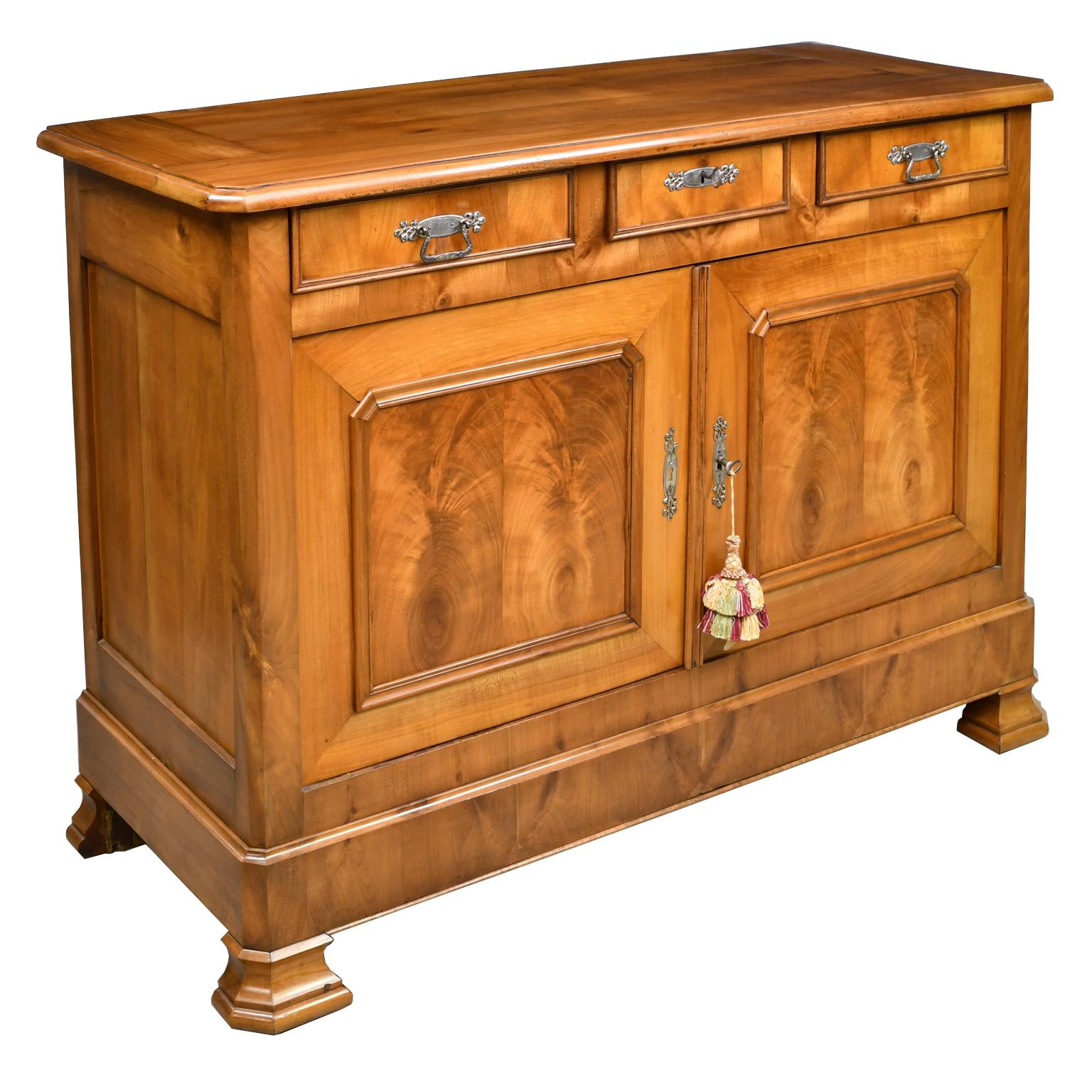 A Louis Philippe buffet in beautiful cherrywood with three drawers over two doors that open to a cabinet with storage area with 1 shelf. Cabinet rests on original ogee faceted feet, France, circa 1840.
Measures: 54 1/4 wide x 21 1/2 deep x 39 1/4