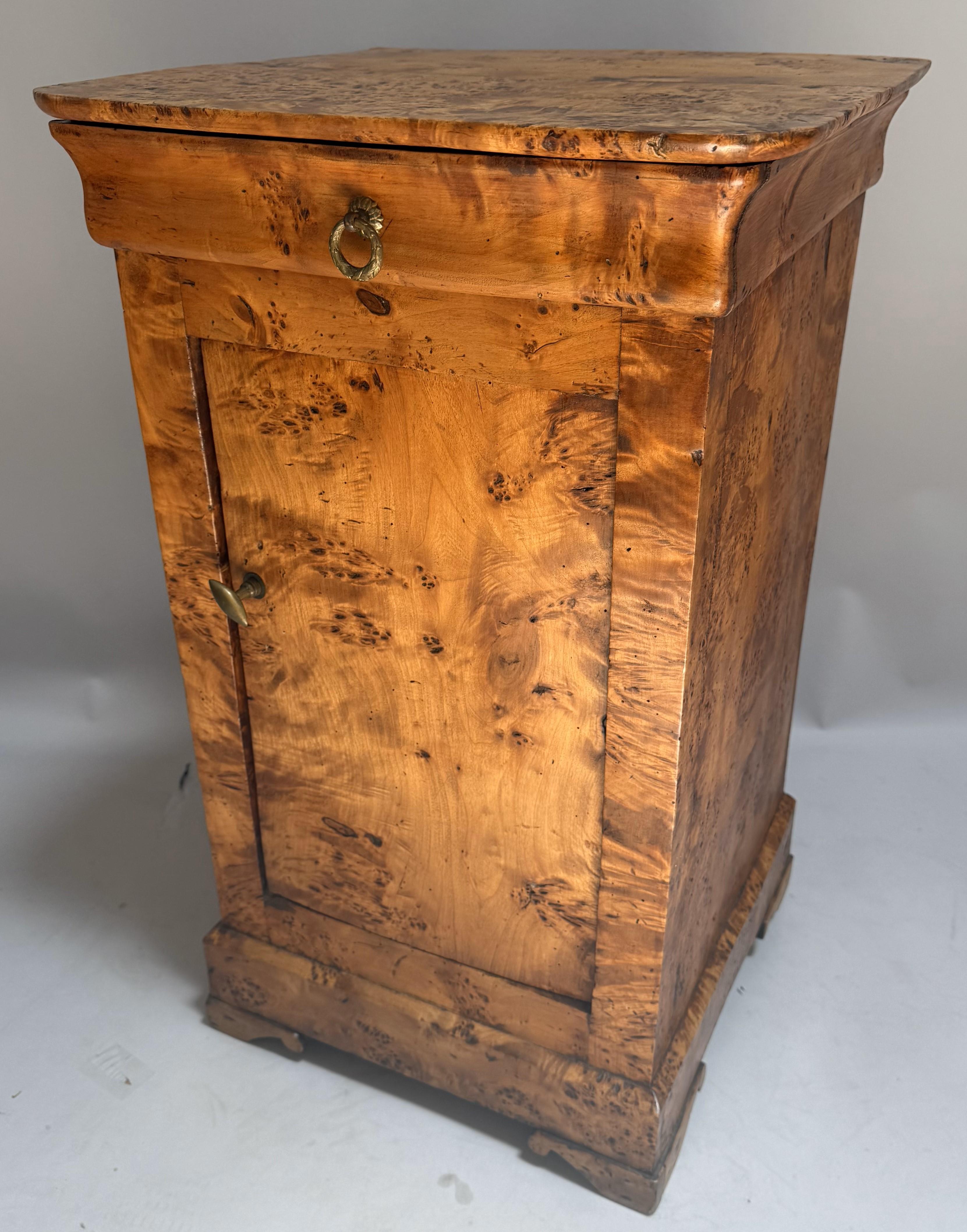A wonderful example of 19th-century French craftsmanship, this Louis Philippe period nightstand showcases exceptional burled yew wood veneer with richly figured grain and a warm, honeyed patina. Crafted circa 1830 near Avranches on the west coast of