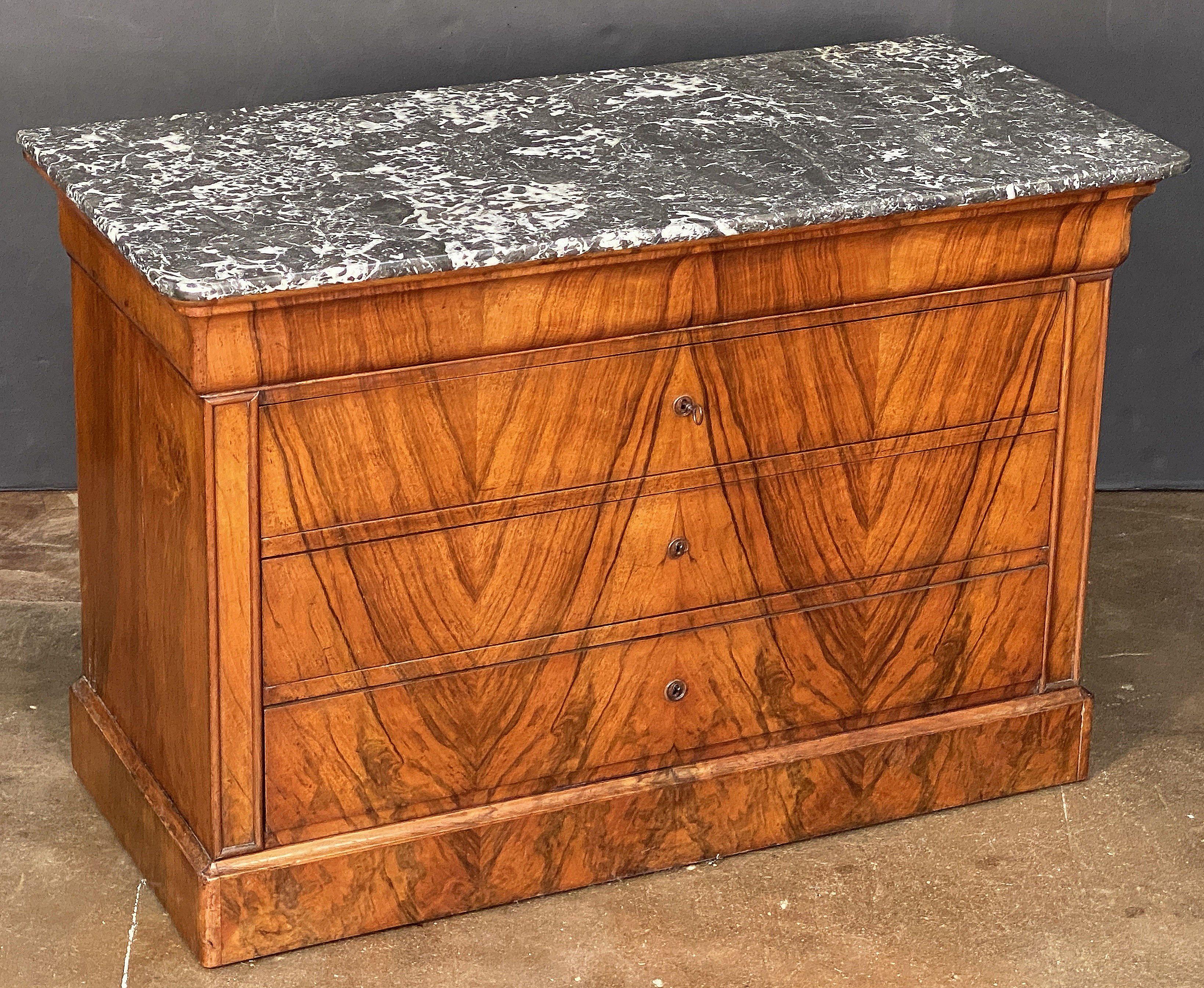 Una bella consolle o commode Louis Philippe proveniente dalla Francia, in legno di noce burlato splendidamente patinato con piano in marmo figurato, dotata di quattro cassetti lunghi e montati, con scanalature in ottone, e posta su una base a