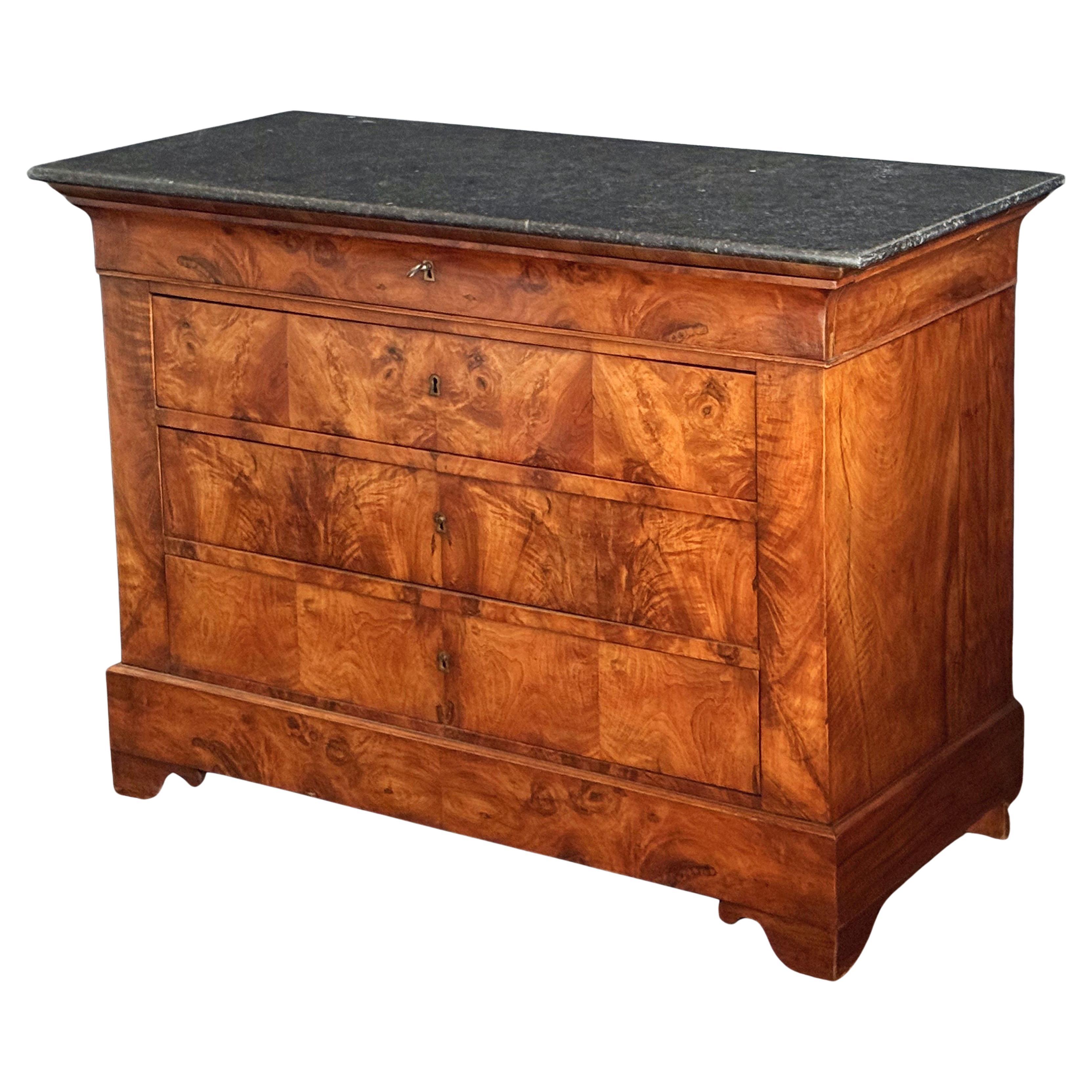 Una bella consolle o commode Louis Philippe proveniente dalla Francia, in noce burlato patinato con un piano in marmo figurato, con quattro cassetti lunghi e montati, con scanalature in ottone e su una base a plinto con quattro piedi sagomati.