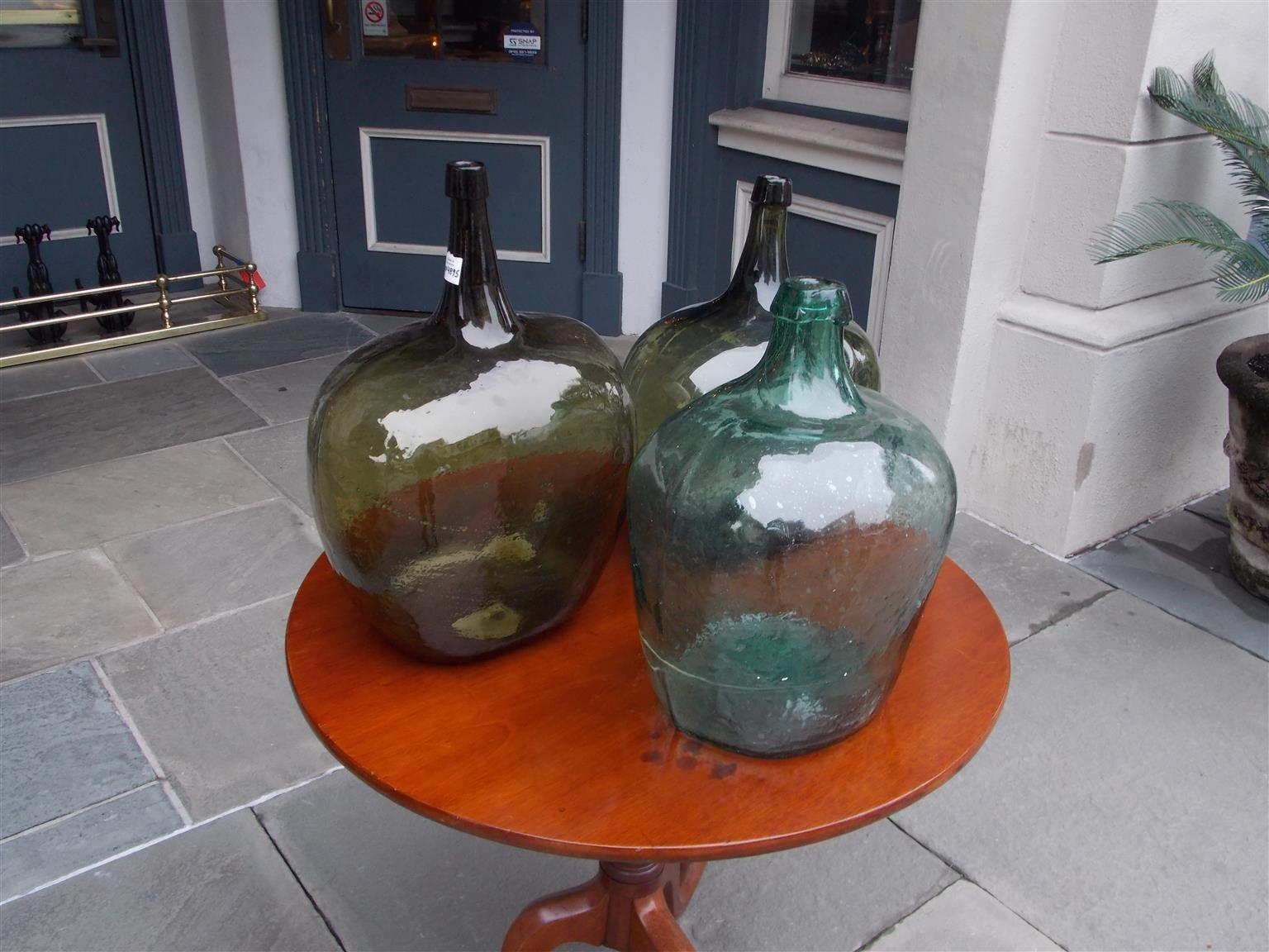 French hand blown three decorative bulbous colored glass wine jugs, Late 19th century. 