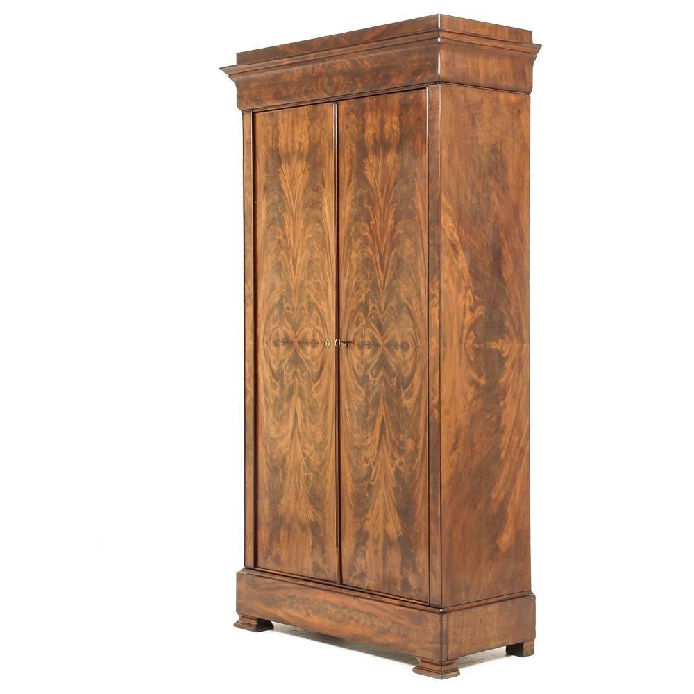 A handsome French Louis Philippe two-door armoire, the doors veneered in dramatic book-matched flame mahogany.
The interior is fitted with a single adjustable shelf with two small drawers; more shelves may be produced as per clients' needs.
At