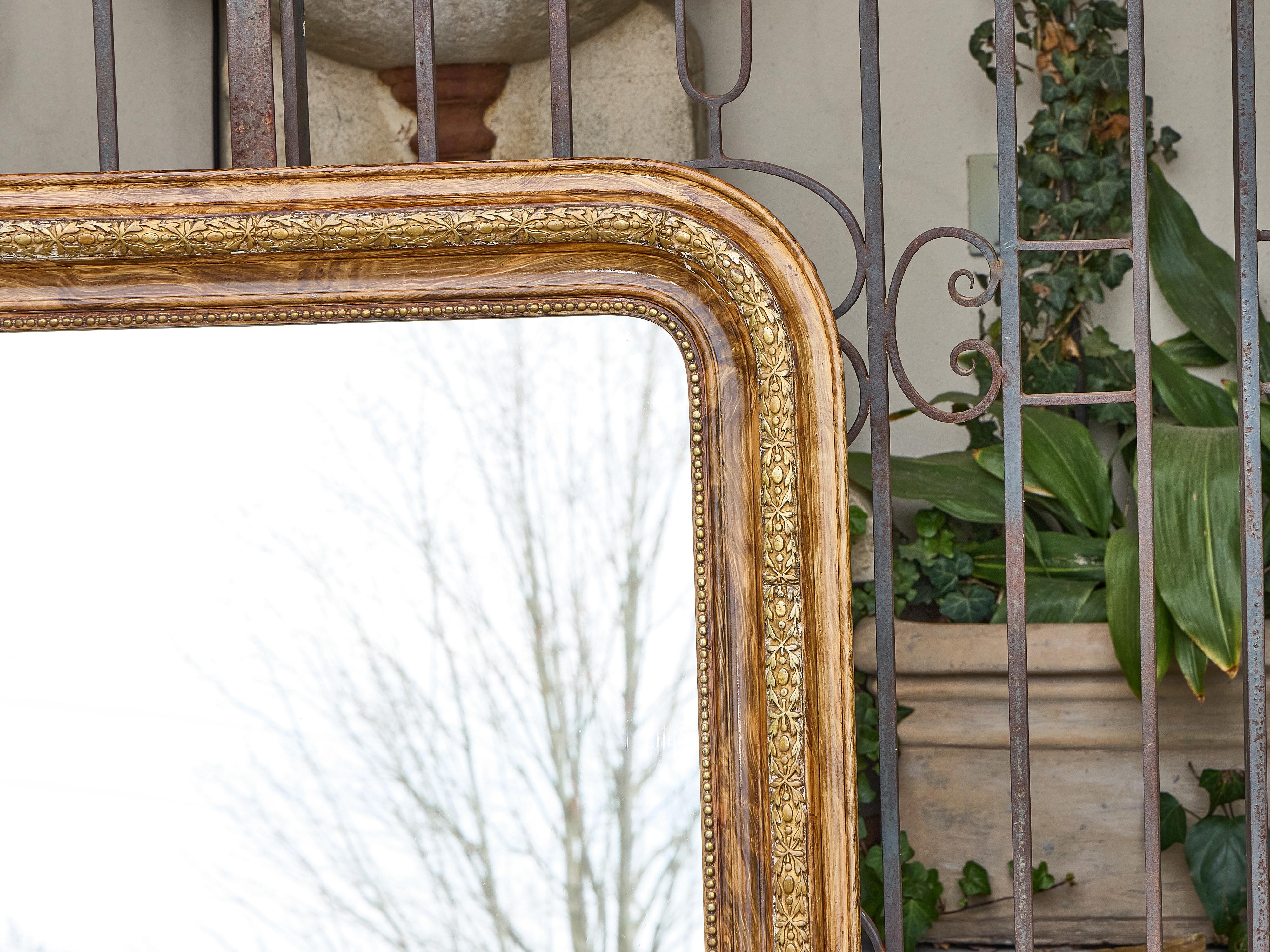 Ce miroir français de Silhouette, datant d'environ 1900, se distingue par sa silhouette classique et sa surface dorée. Le cadre rectangulaire présente des angles supérieurs légèrement incurvés et une simplicité raffinée qui définit la période