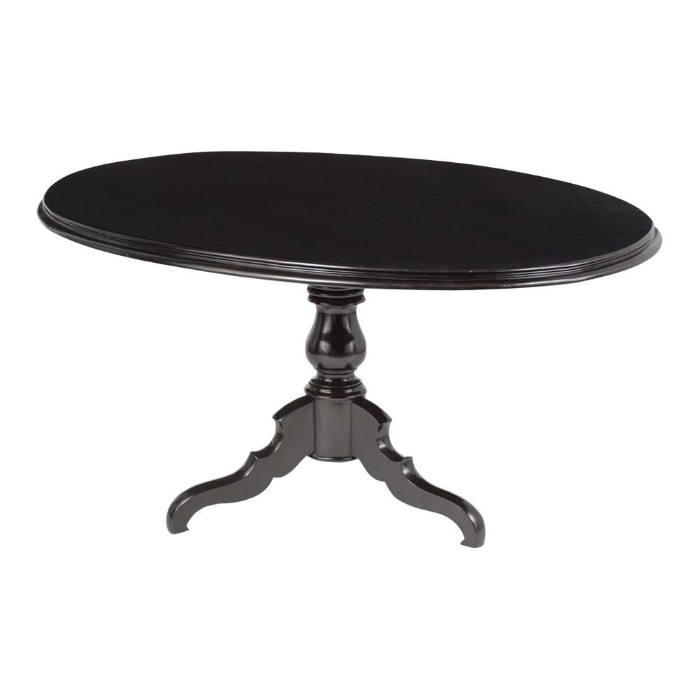This 19th century French Louis Philippe style dining table is made out of mahogany wood and has been stained a rich black color with a newly lacquered finish. The table has a solid oval shape top, hand-carved detail molding, and rests on an elegant