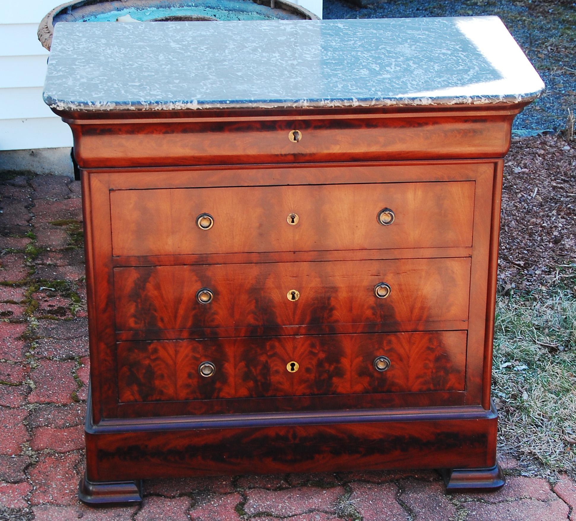 French Louis Philippe period finely figured mahogany chest of four drawers with original marble top. In this period most of the chests of this design were fairly large, but this one is only 38 1/2 inches wide which makes it unusual. The timber used