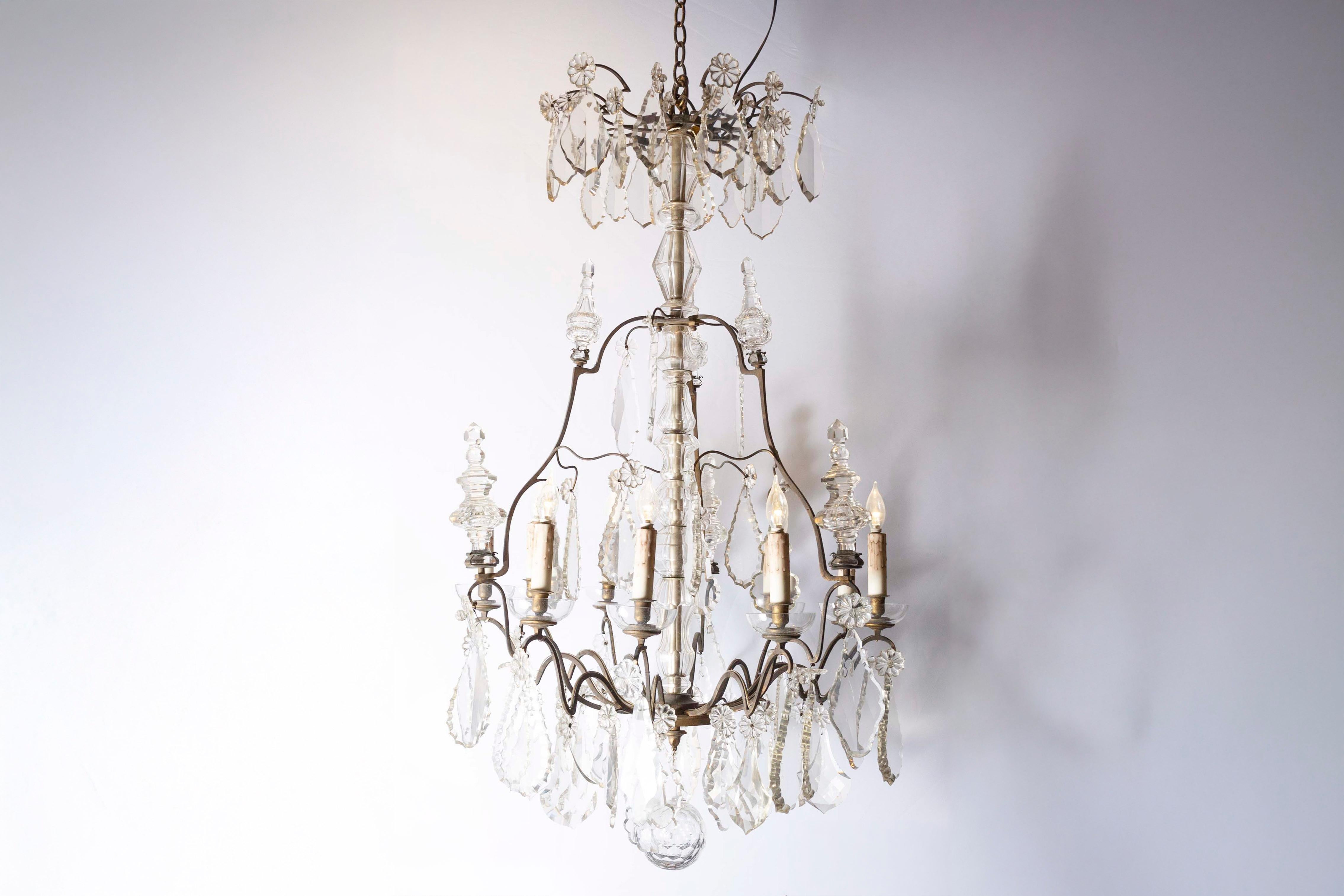 Lustre français à neuf lumières en cristal du milieu du XIXe siècle, avec armature en fer. Né en France sous le règne du roi Louis-Philippe, ce lustre exquis présente une colonne centrale en cristal, entourée d'un anneau de pendeloques et de rosaces