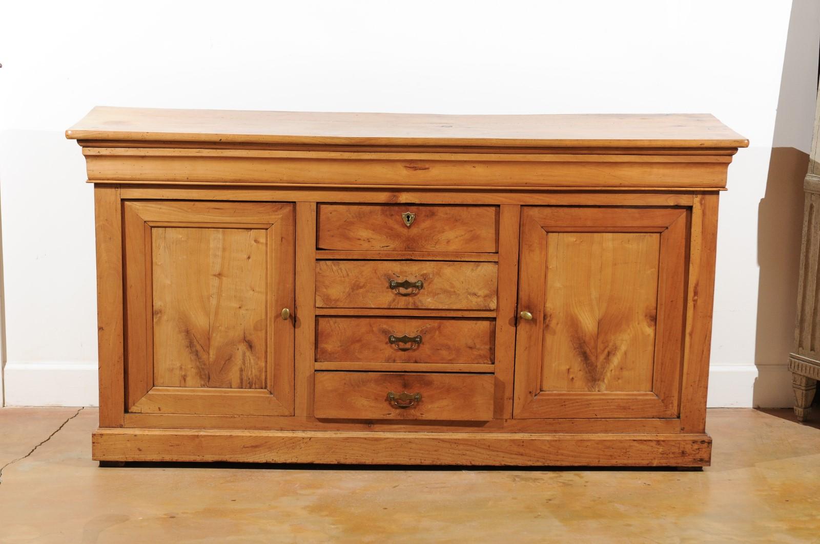 A French Louis-Philippe period walnut enfilade from the mid-19th century, with doors and drawers. Born in France at the end of the Louis-Philippe period, this exquisite walnut sideboard features a rectangular top sitting above a molded apron. The